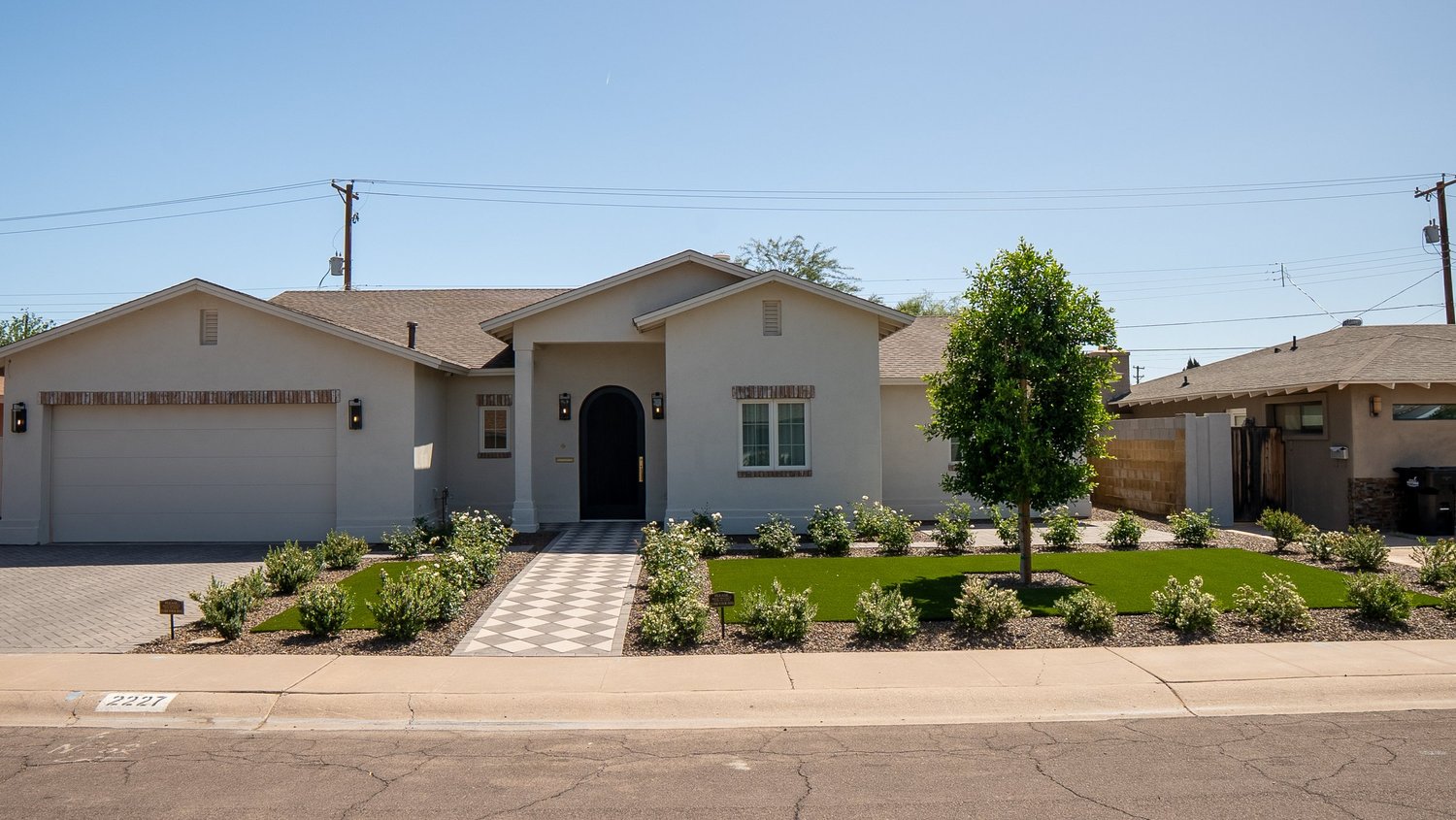 Full front elevation with brick paver driveway, turf, and rose landscaping — Valley Estates