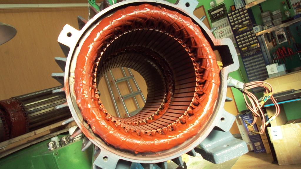 Stator sa crvenom bakrenon namotanom i bijelim hladnjačkim rebrama sa zelenom kontrolnom elektronikom