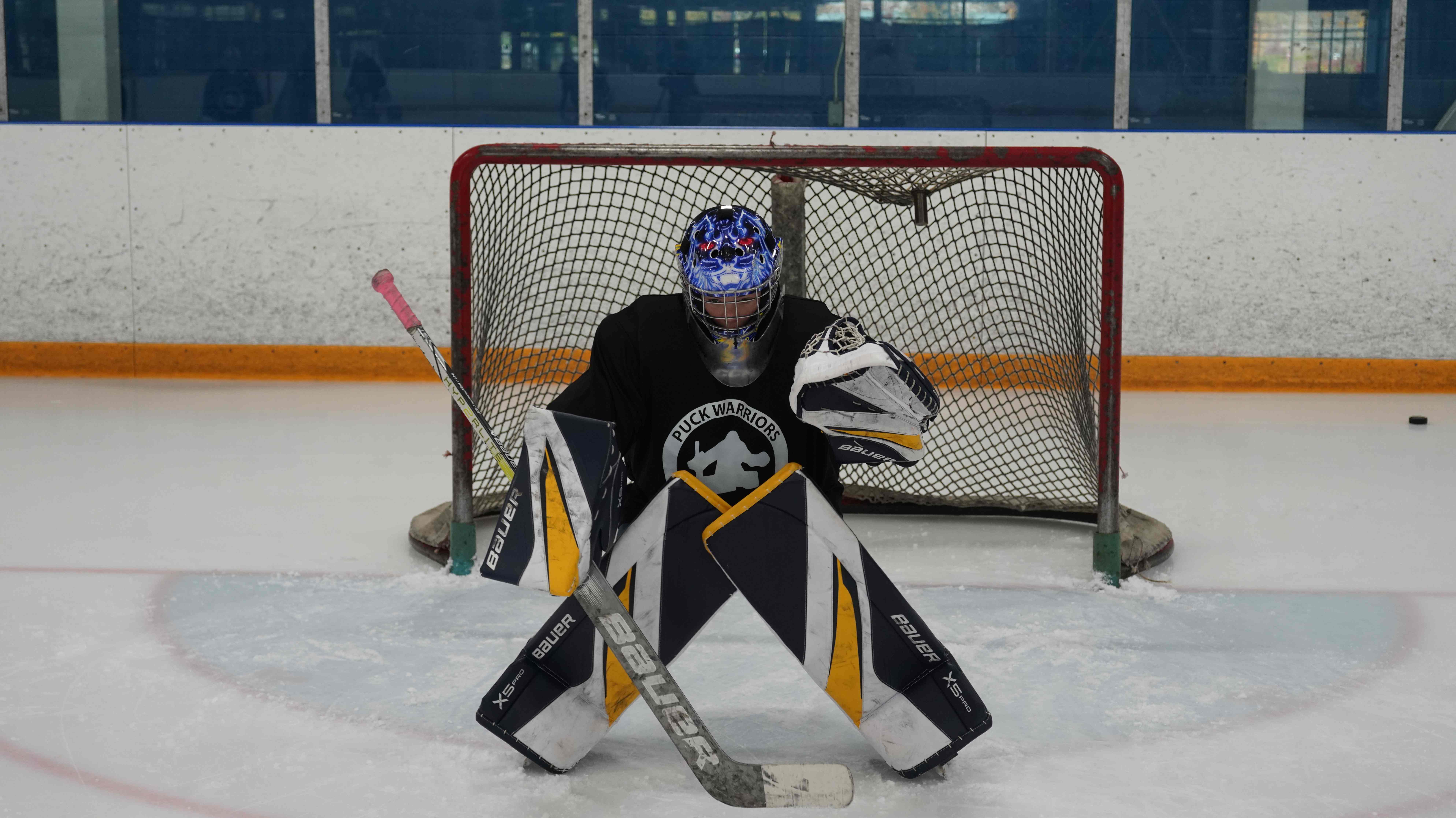 Goalie sealing the ice in a butterfly in front of the net