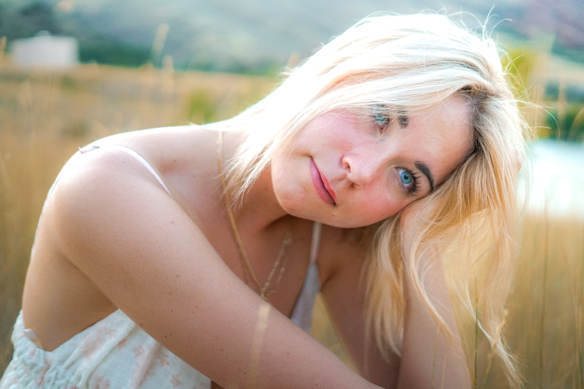 Senior portrait - blonde woman with dreamy expression in field
