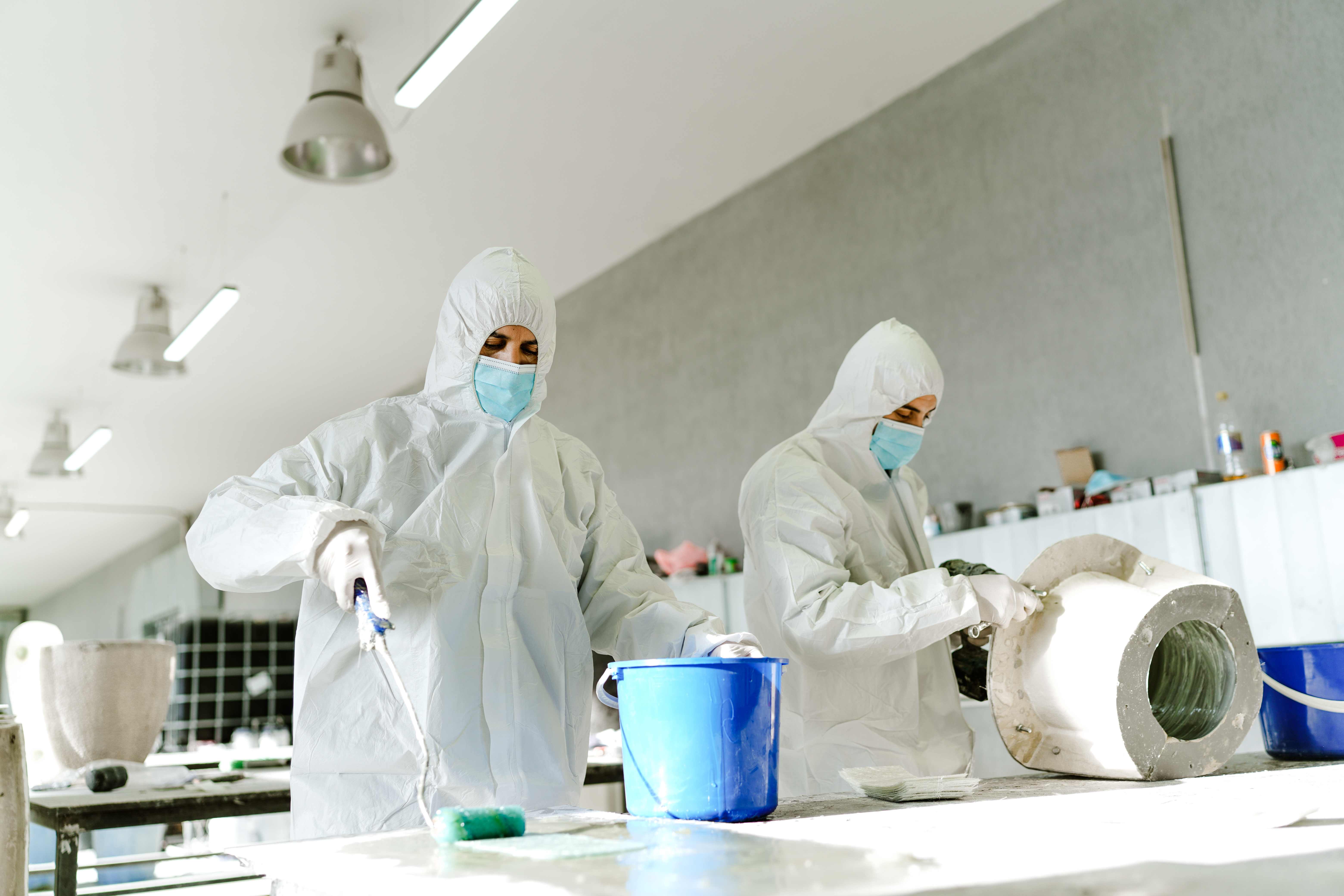 Due operai laminano a spruzzo l'interno di un grande stampo cilindrico