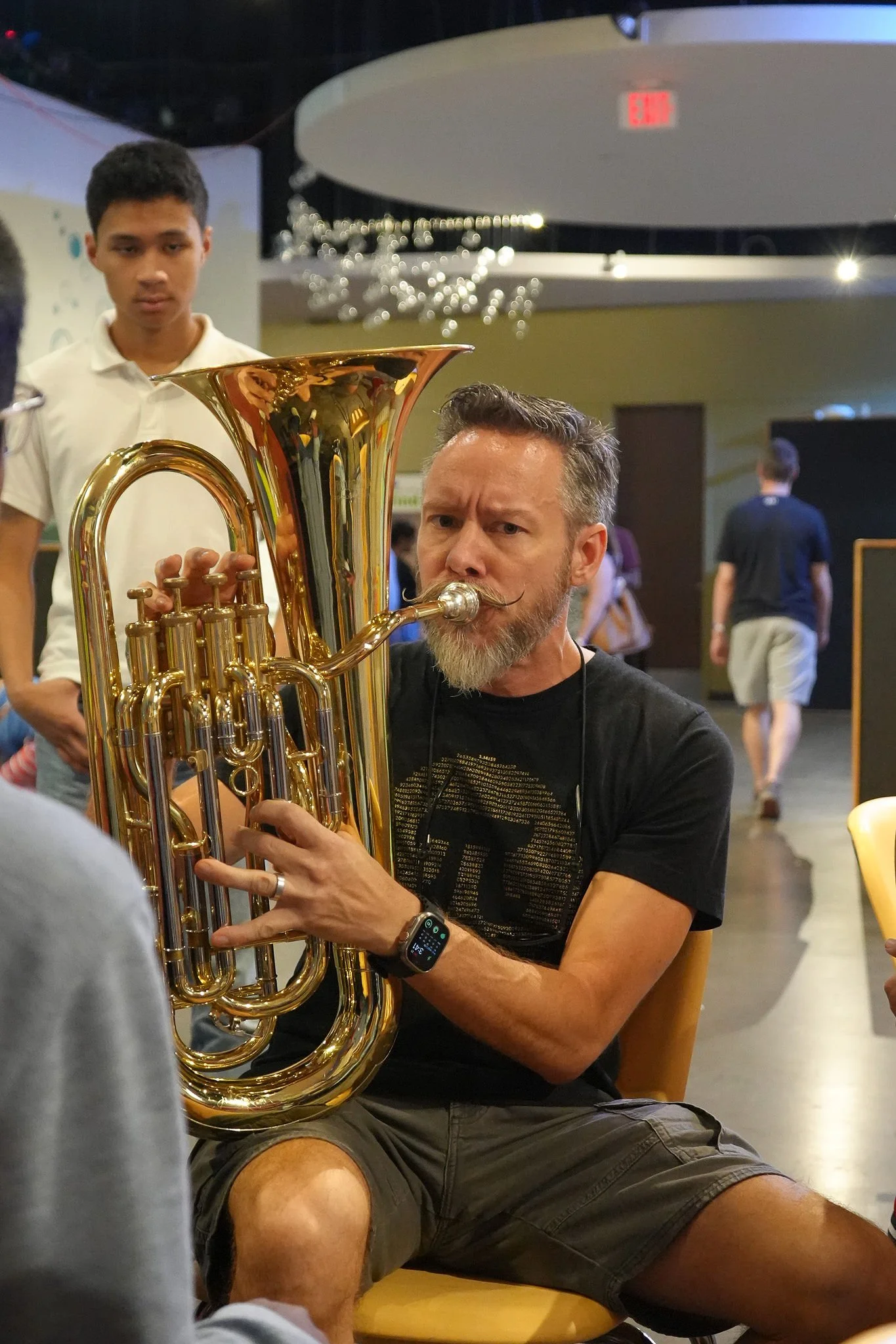 Adult playing tuba at community event
