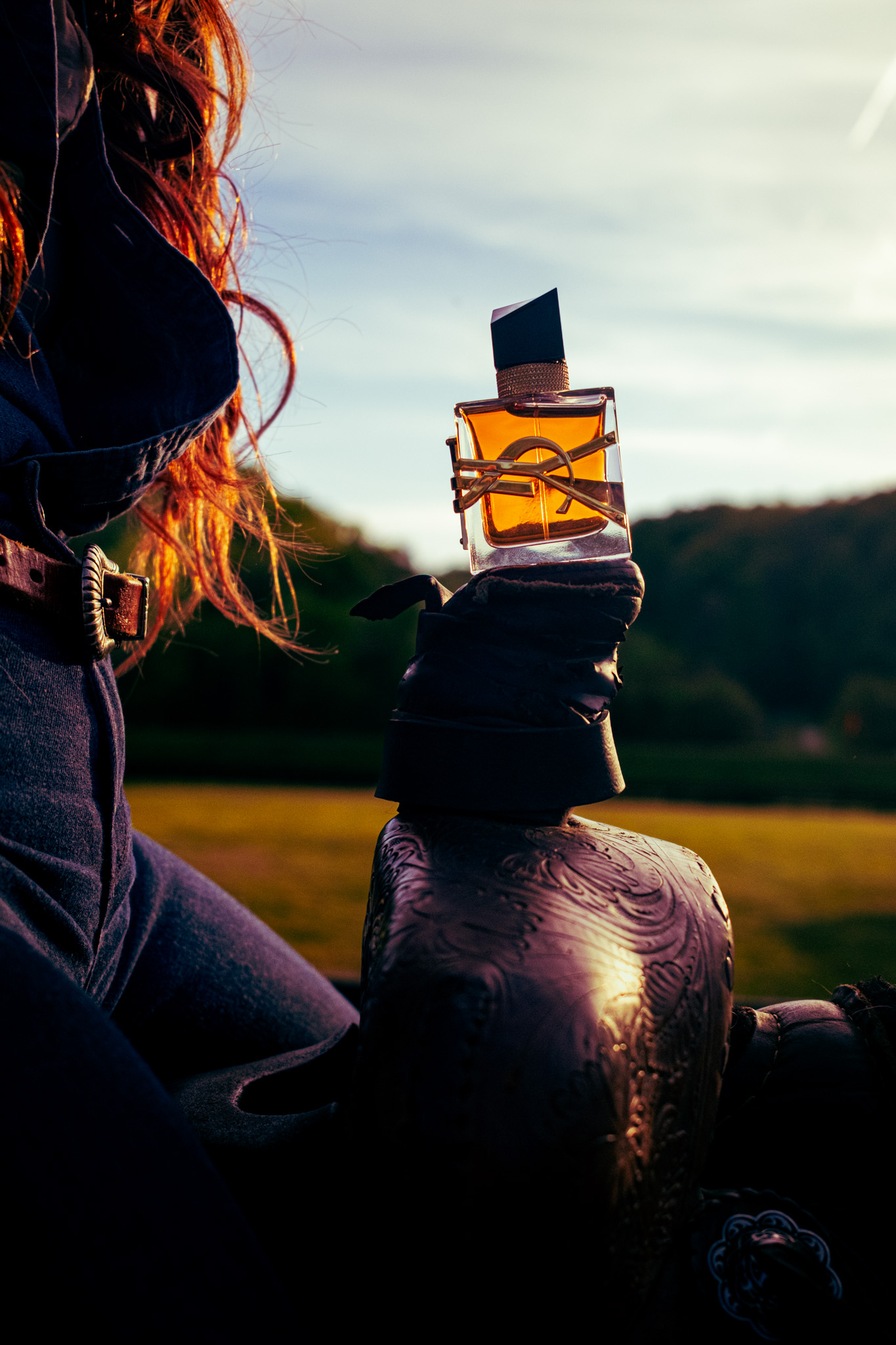 YSL Libre perfume on leather saddle at golden hour