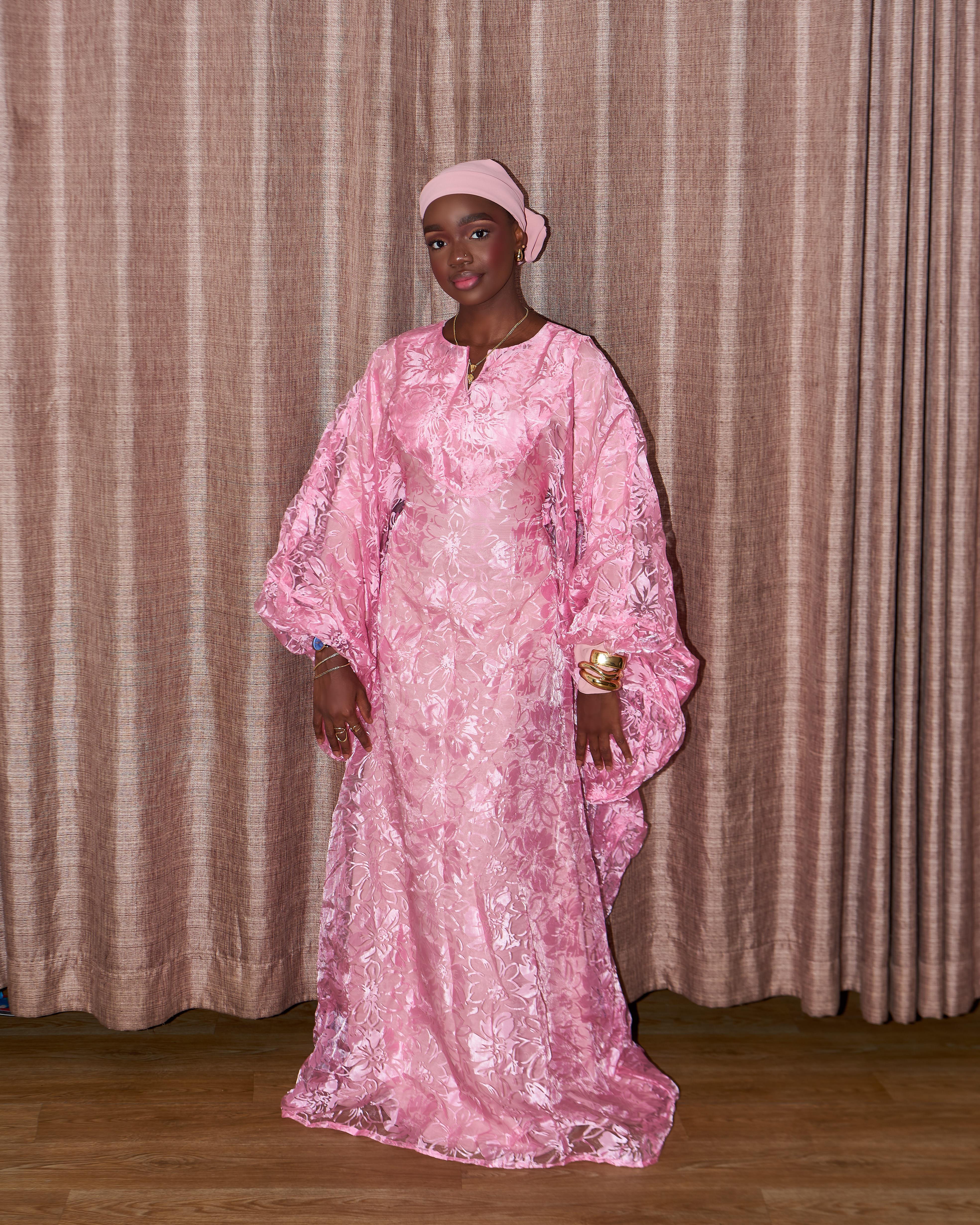Suliat in a pink floral dress and headscarf