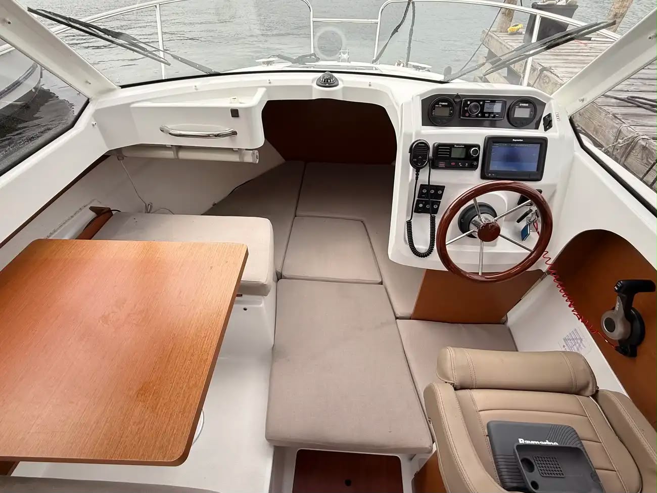 Wide interior view showing the dinette, helm and skipper seat together