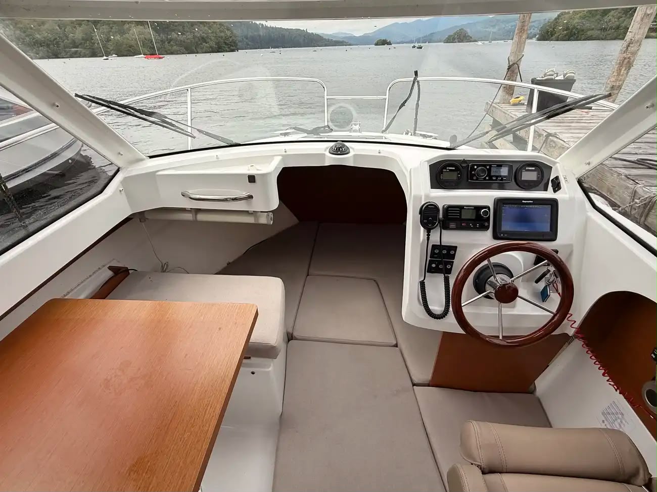 The bright interior with dinette and helm looking out to the lake
