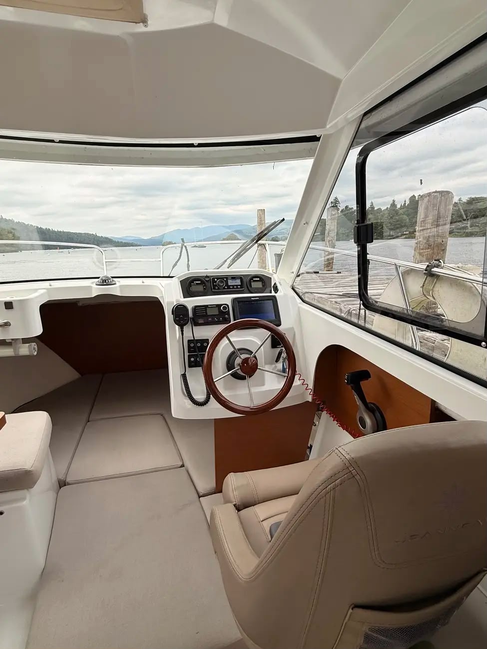 Wide view of the helm and helm seat inside the enclosed wheelhouse