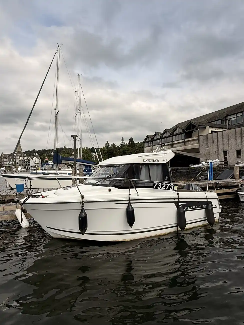 Side profile of the Merry Fisher 605 moored at the marina