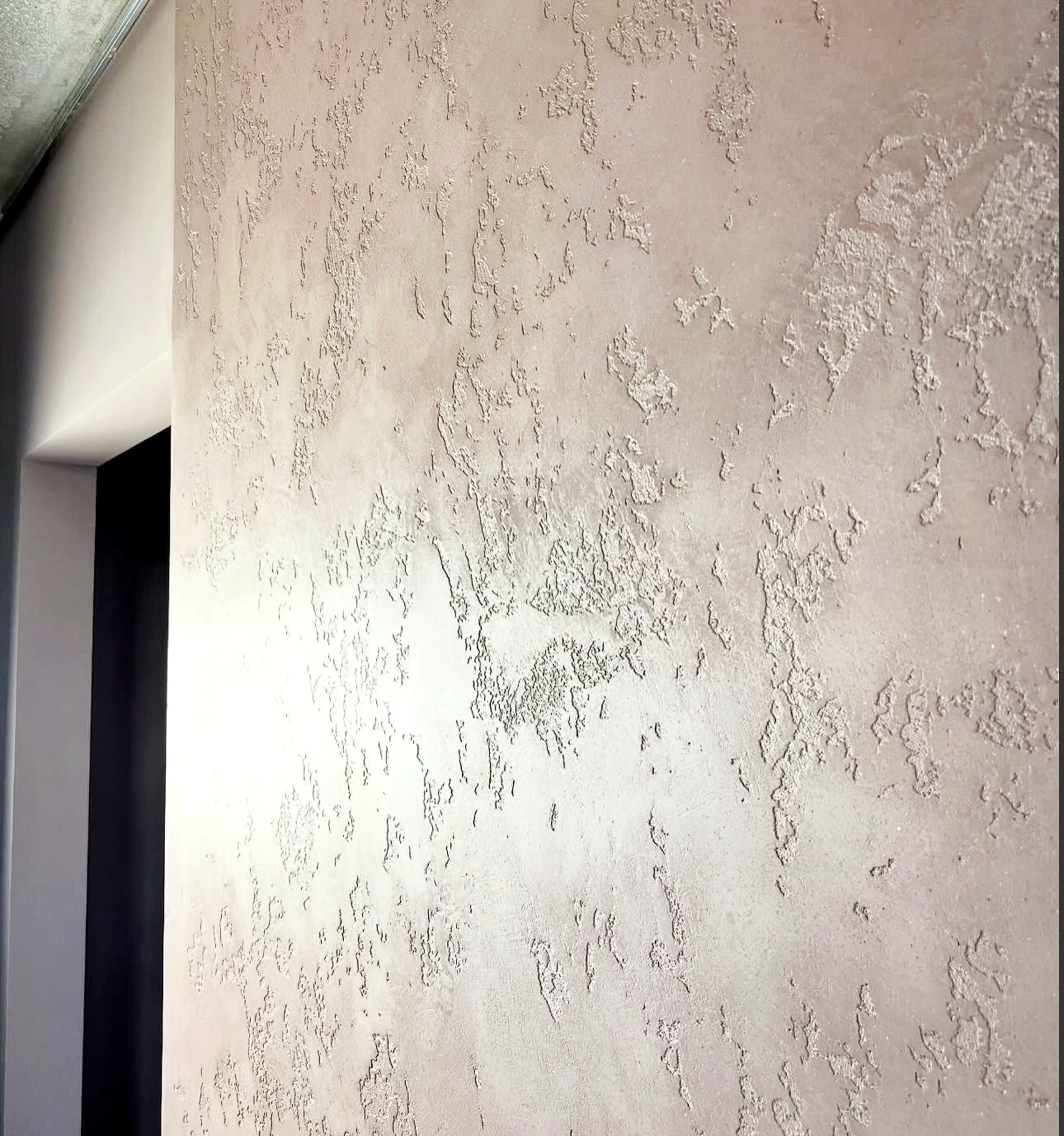 Smooth textured plaster wall finish with natural light variations