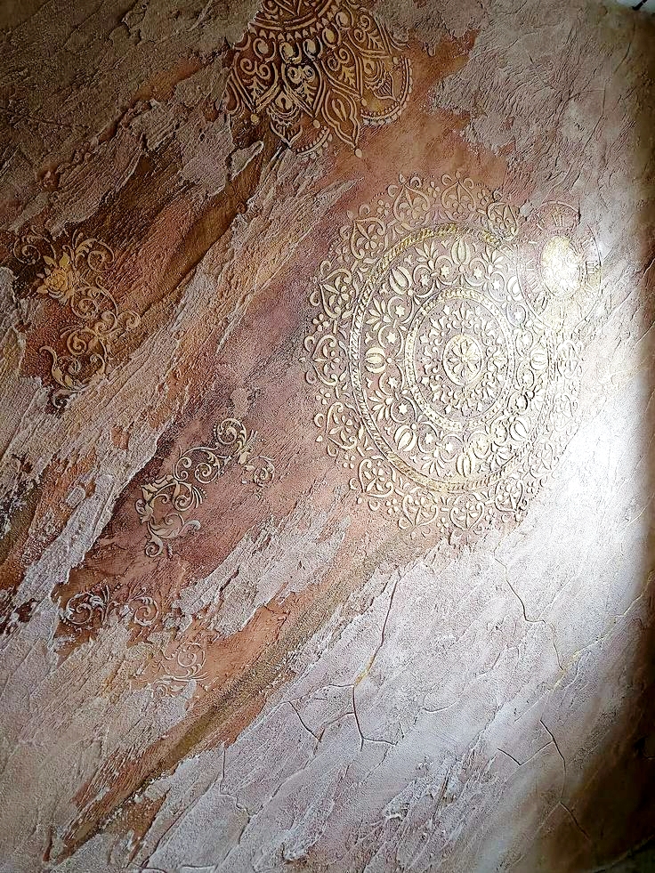 Ornate decorative plaster wall with hand-applied artistic patterns