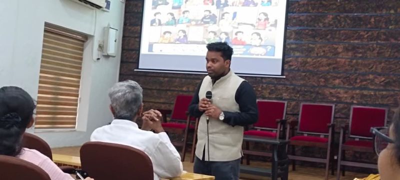 Dr. Umeshkumar KU delivering a lecture with a microphone to an audience at UC College