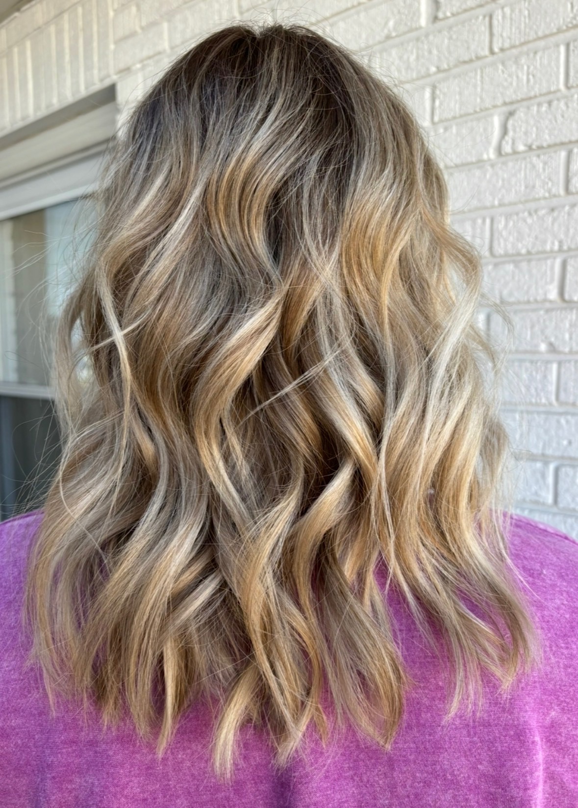 Wavy blonde balayage with dark roots
