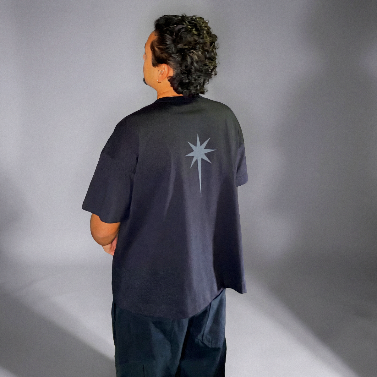 Camiseta Getê Studios preta - Modelo costas com estrela