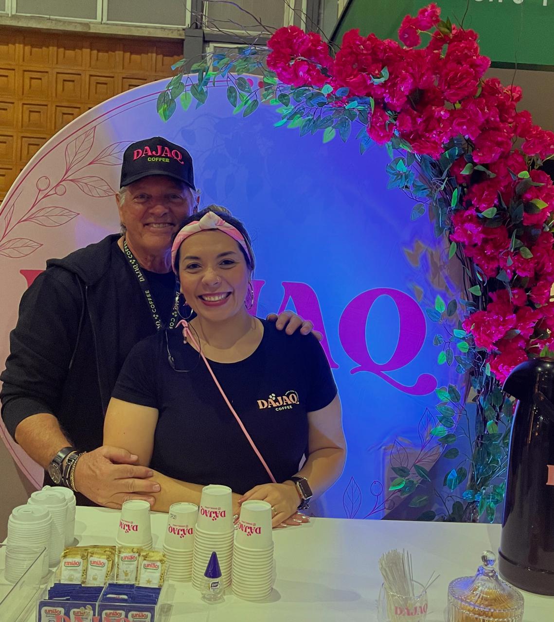 Equipe DAJAQ COFFEE servindo café em uma estação decorada com flores