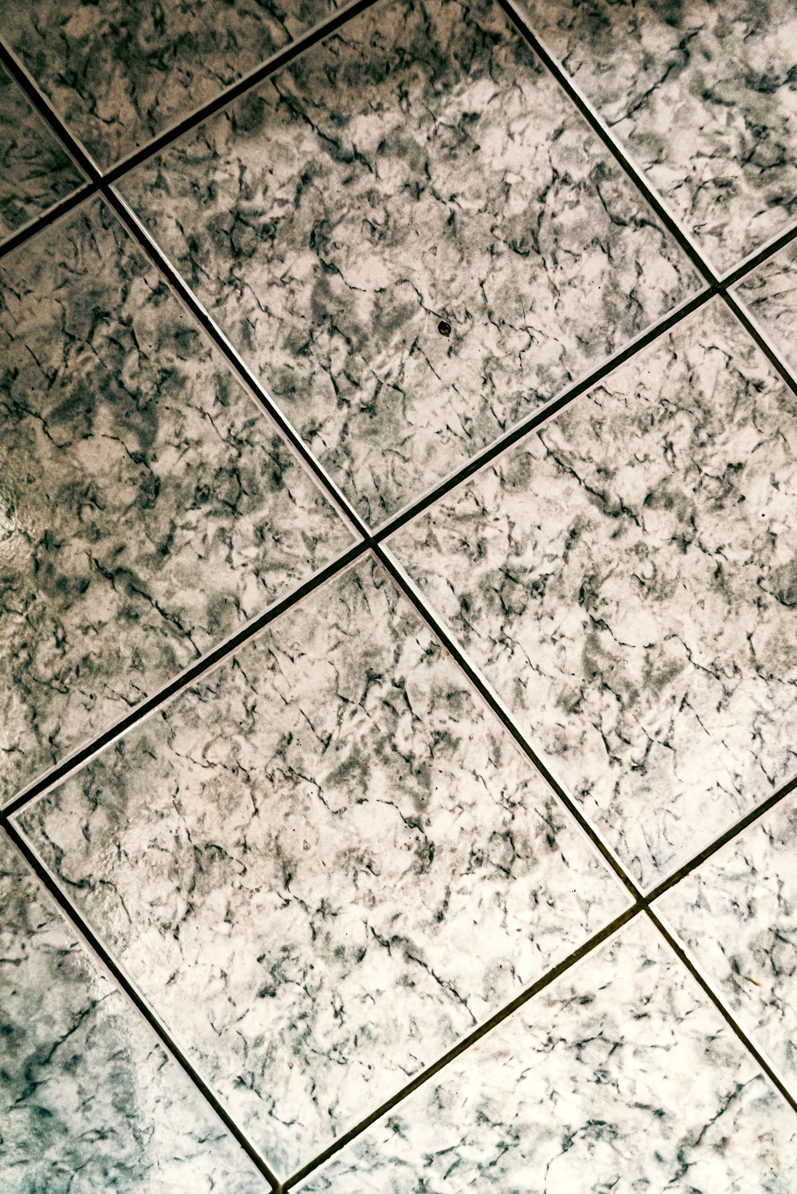 Large format Calacatta marble tiles with herringbone pattern and black grout joints