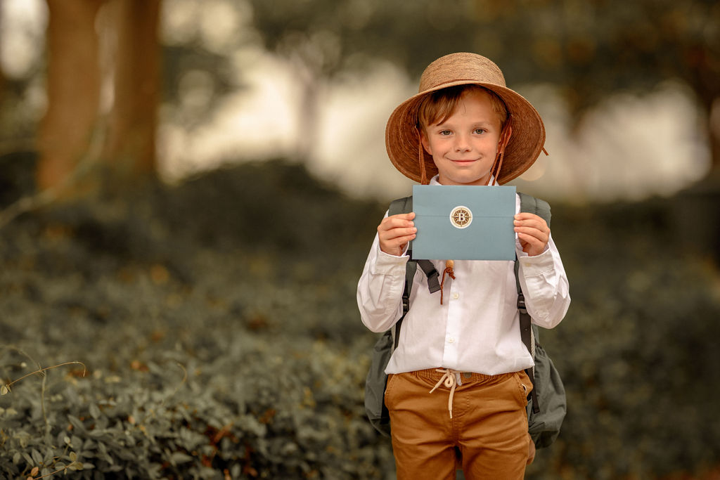 Beckett holding up a Backpacking Beckett envelope with compass seal