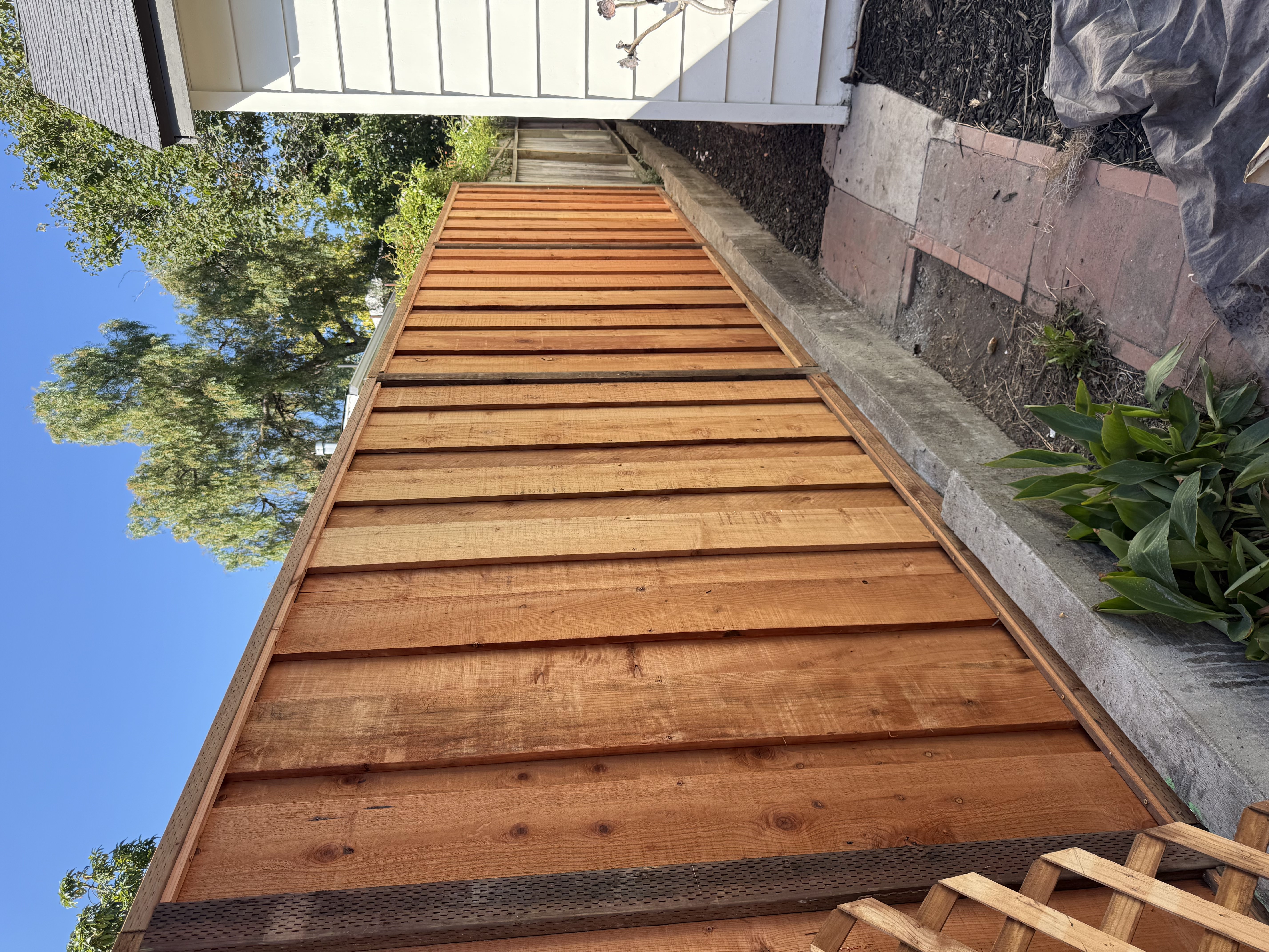 Board-on-board redwood fence with lattice top detail
