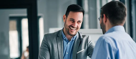 Two professionals in a business meeting, smiling