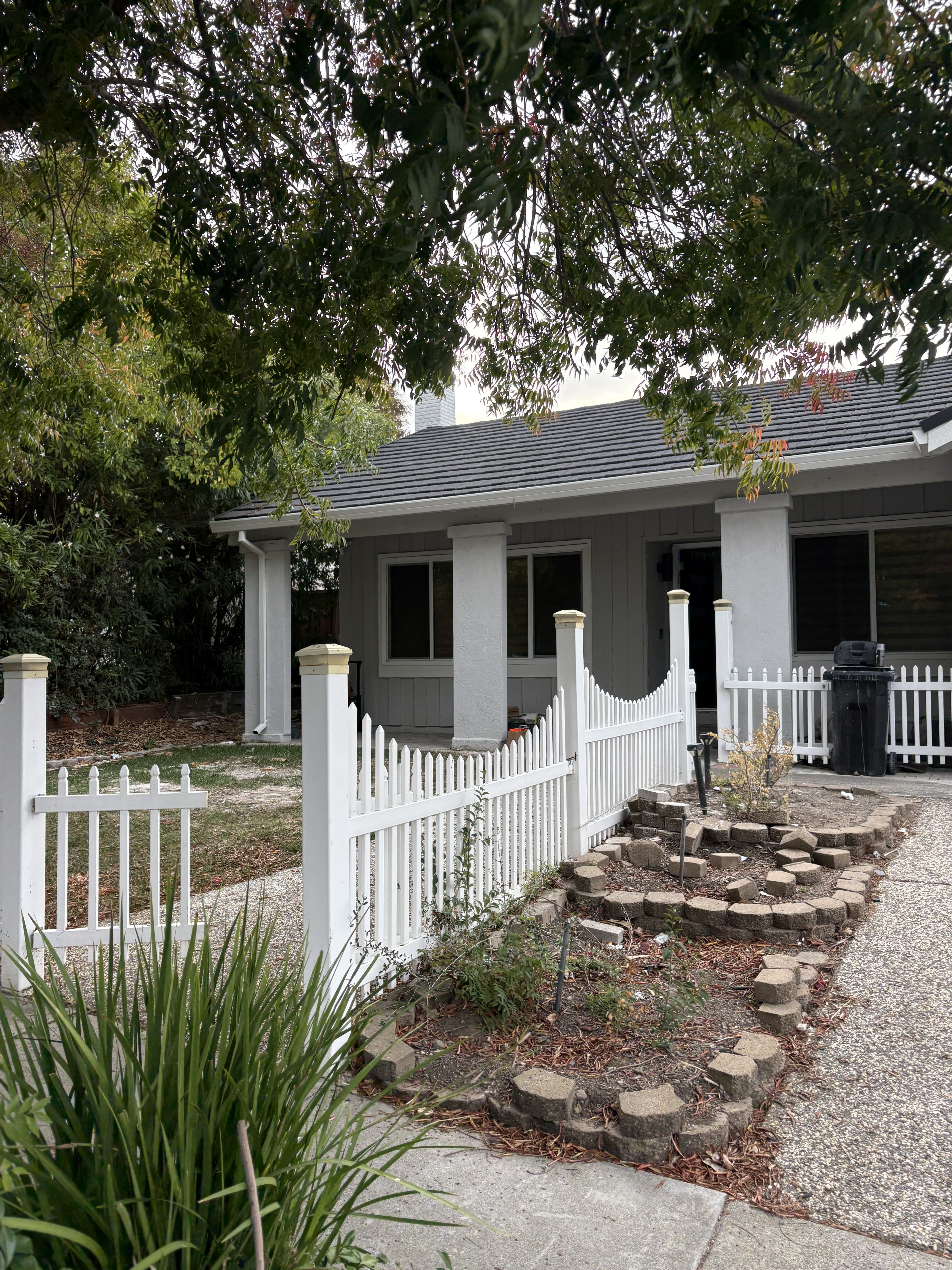 Front yard before - dated picket fence and minimal landscaping