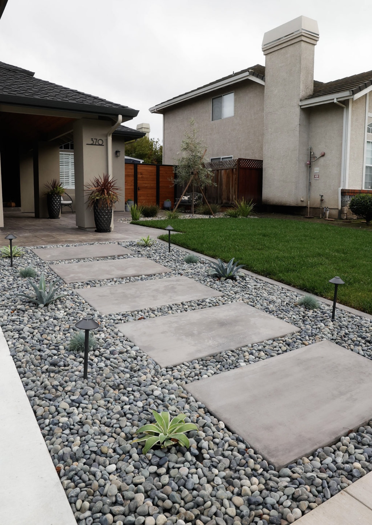 Front yard landscaping with stepping stones, gravel, and drought-tolerant plants