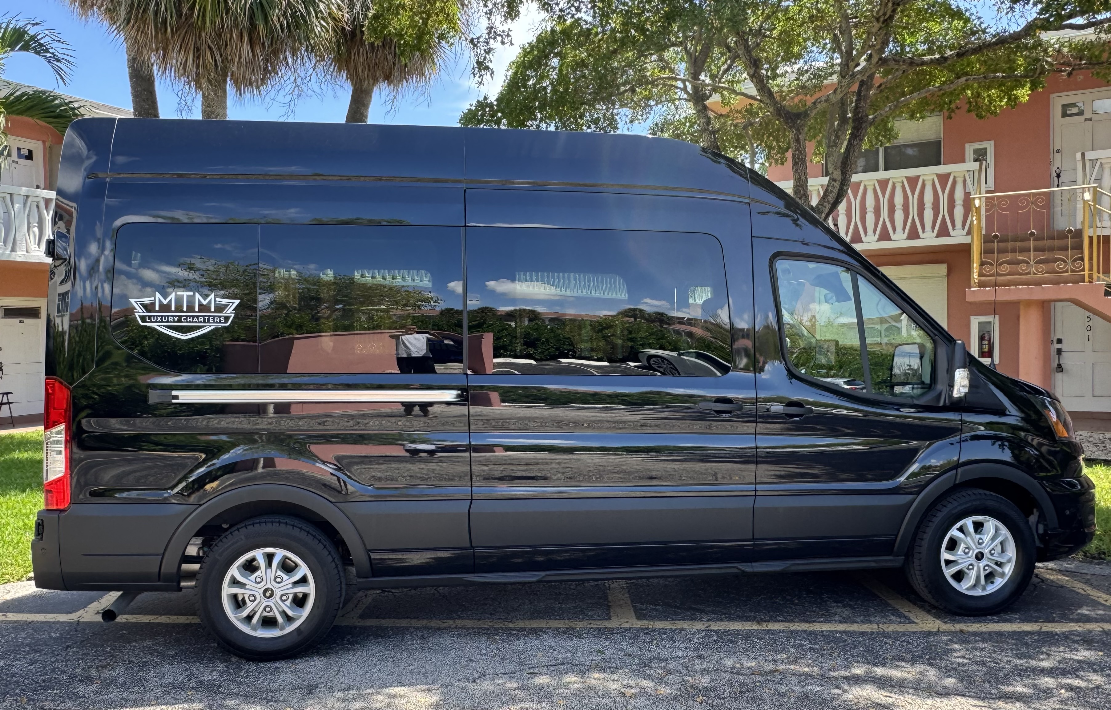 Ford Transit shuttle van exterior, black with MTM Luxury Charters branding