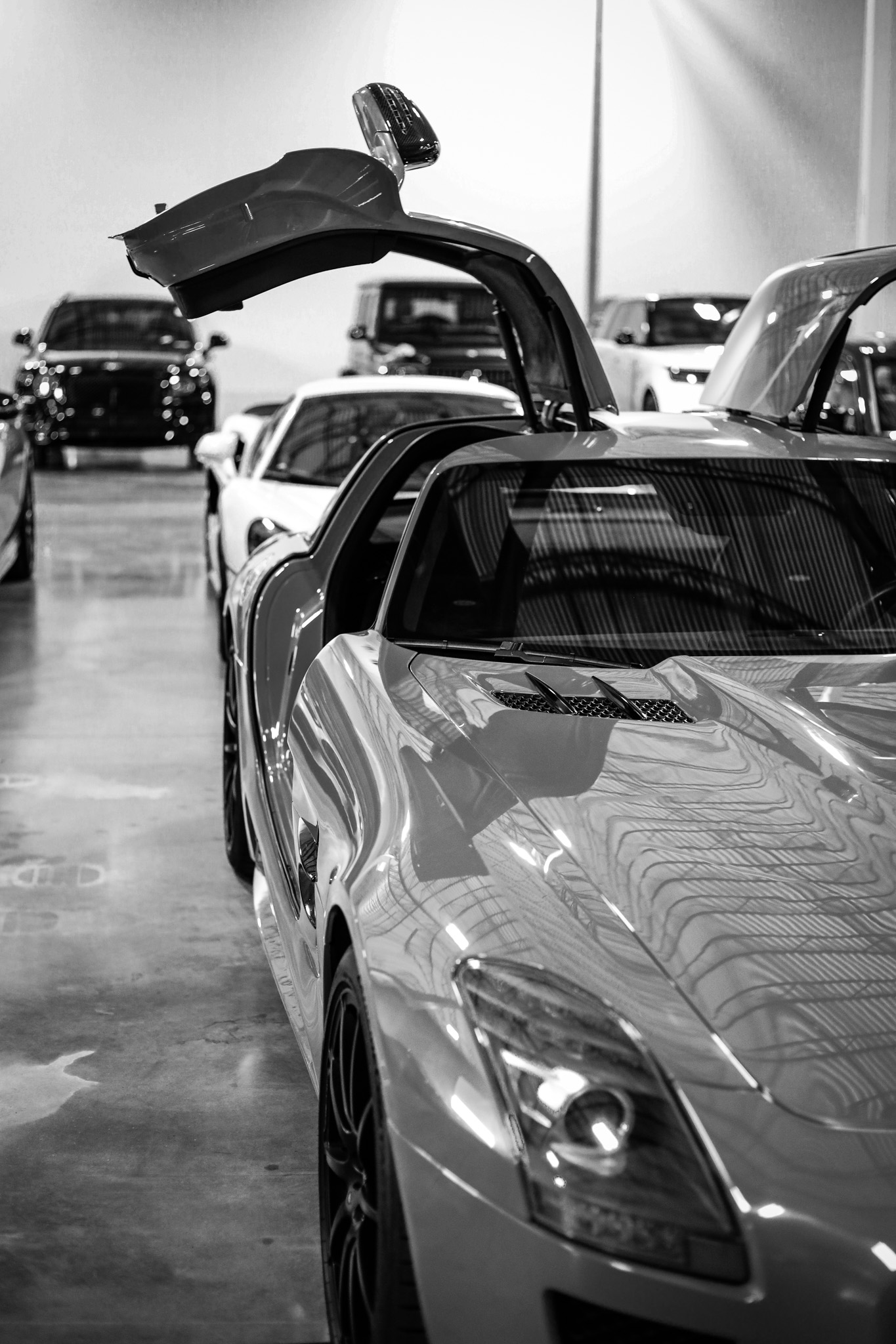 Black and white Mercedes SLS AMG with gullwing door open, silver body, editorial