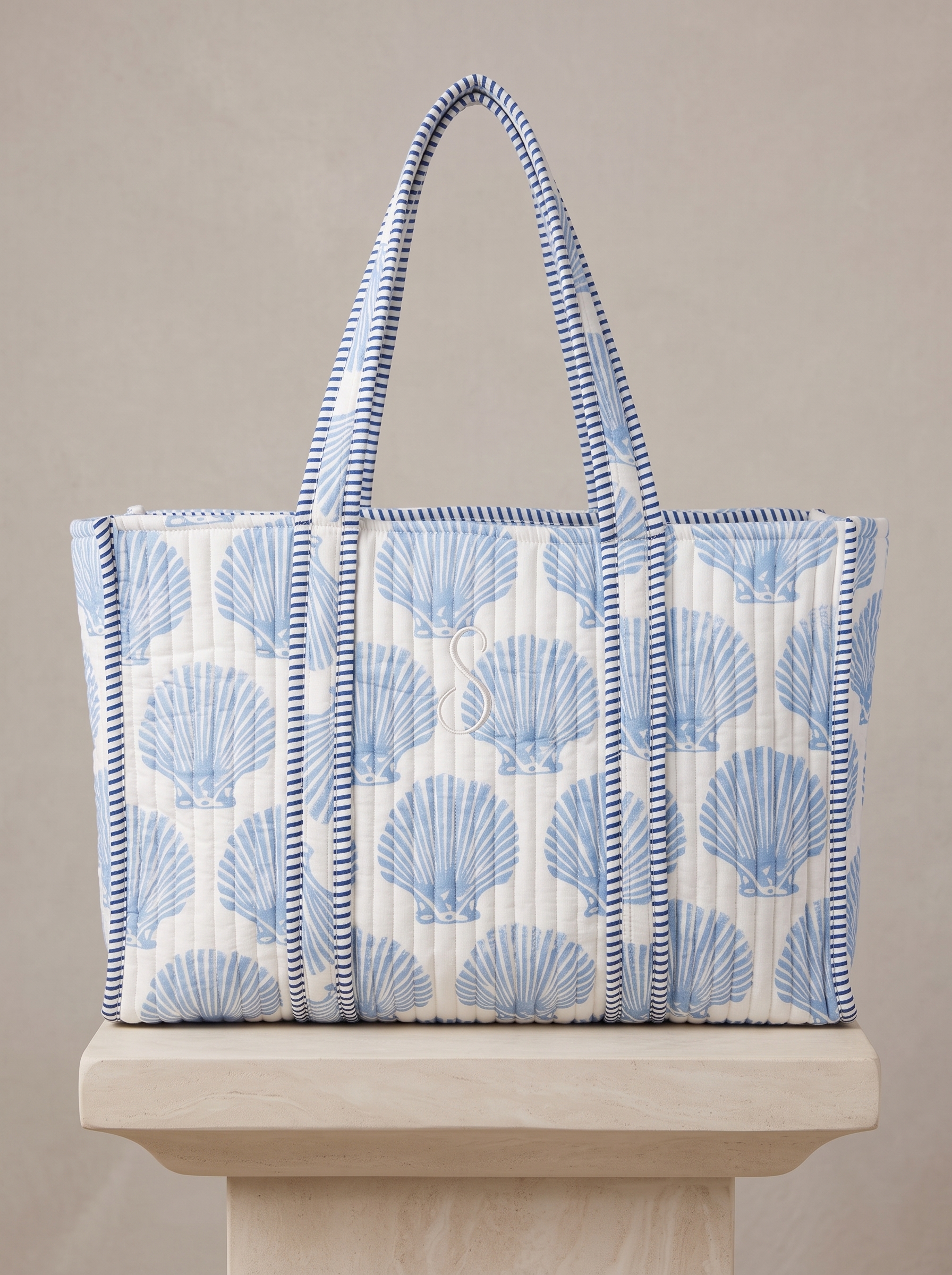 Quilted white tote with pale blue seashells and striped handles