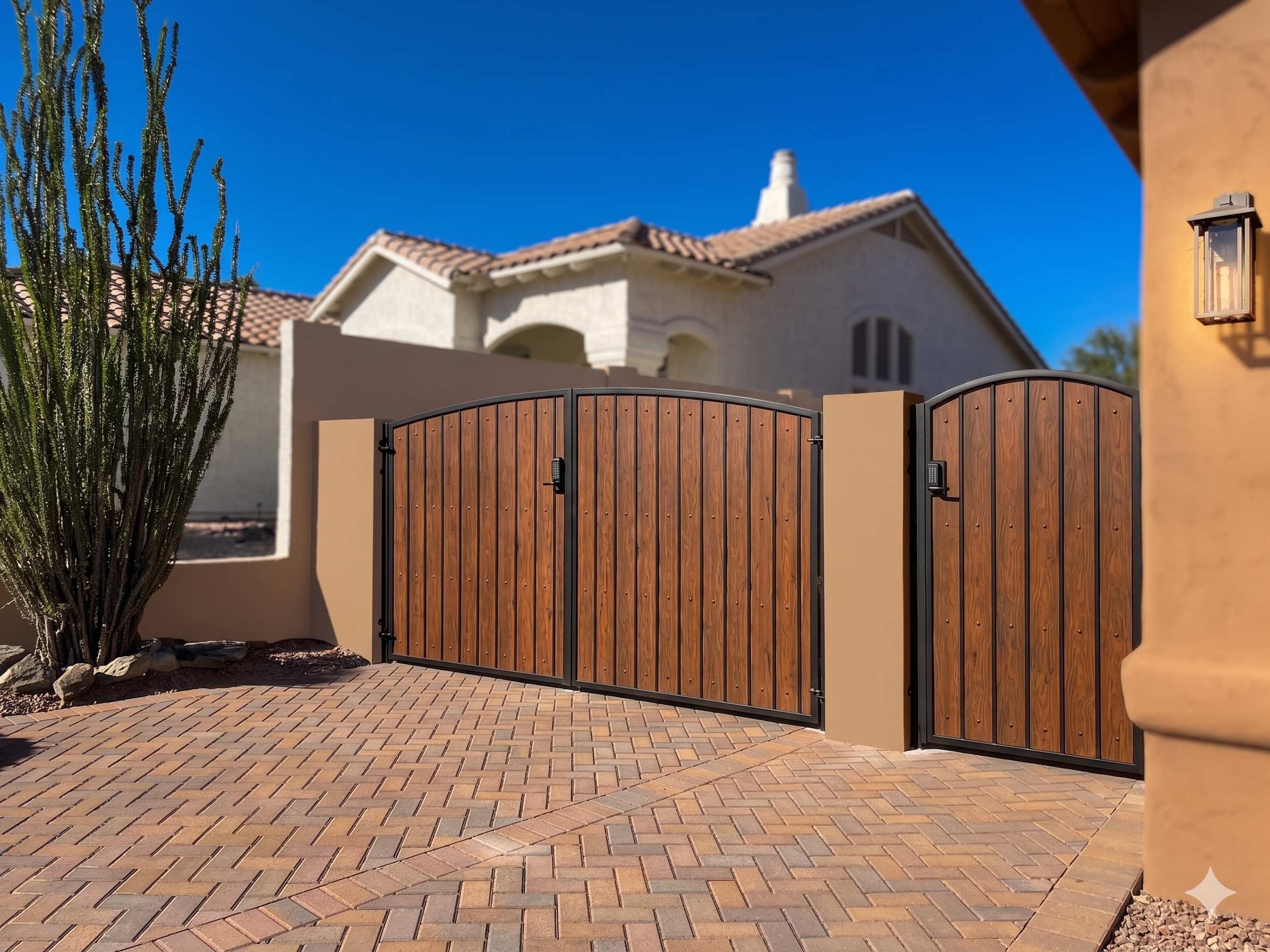 Double gate with matching side gate featuring wood grain panels on paver driveway