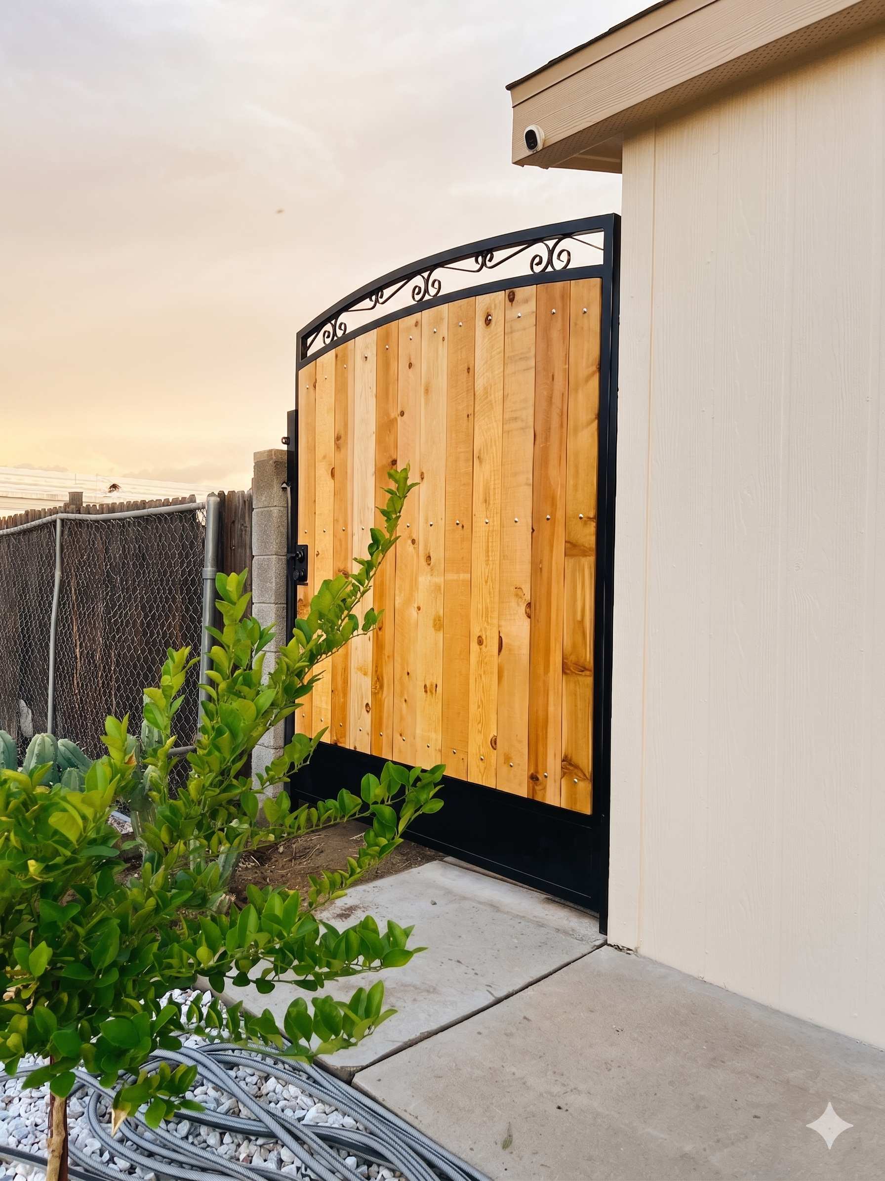 Arched side gate with natural cedar wood and decorative scrollwork