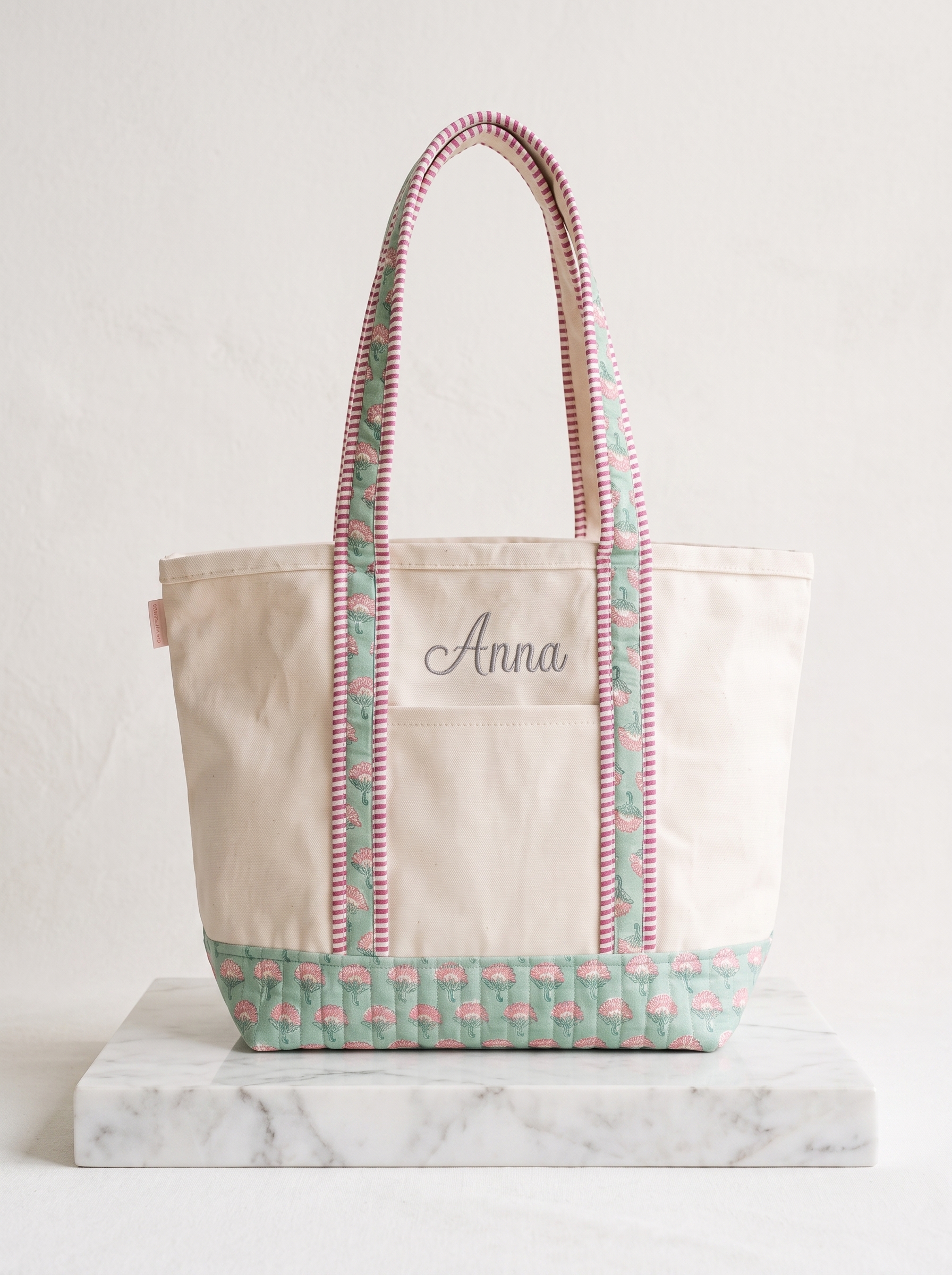 Made from cotton canvas, this tote features a personalized name and floral contrast panels.