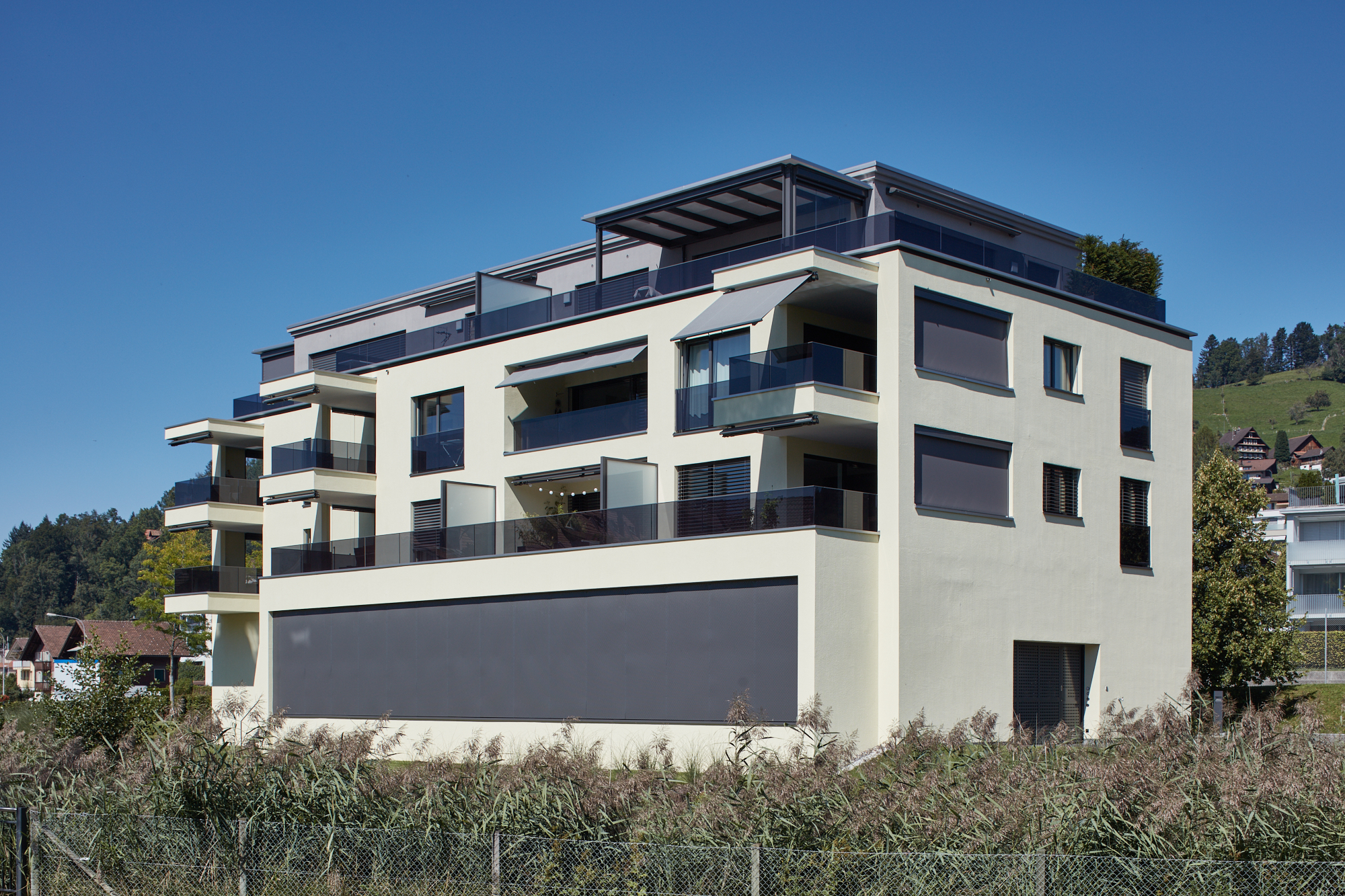 Terrassenhaus mit dunklen Glasbrüstungen und grosser Garage