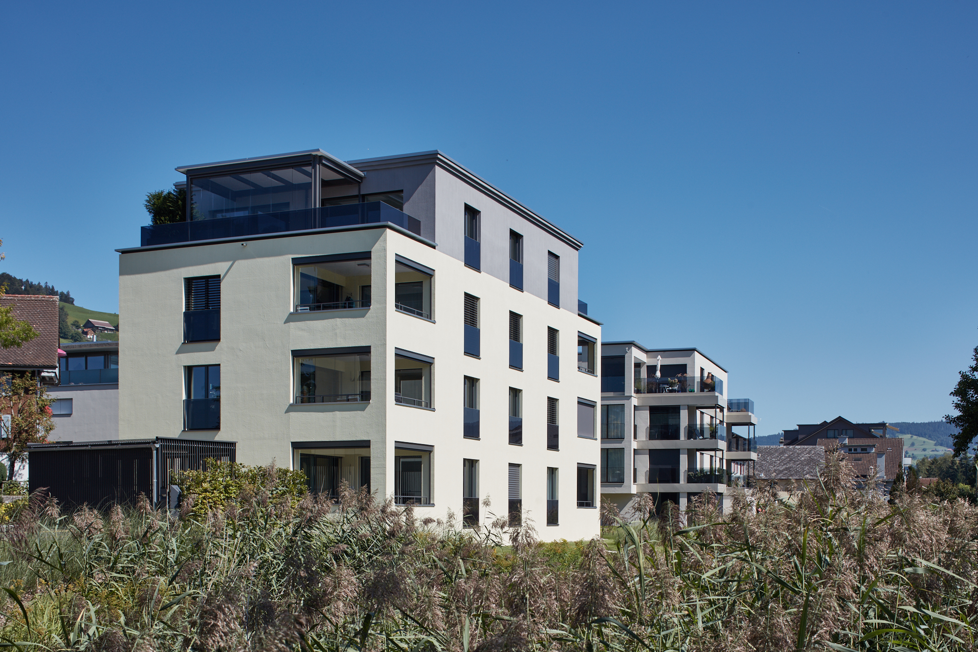 Modernes Wohnhaus mit grosszügigen Fenstern und Dachterrasse
