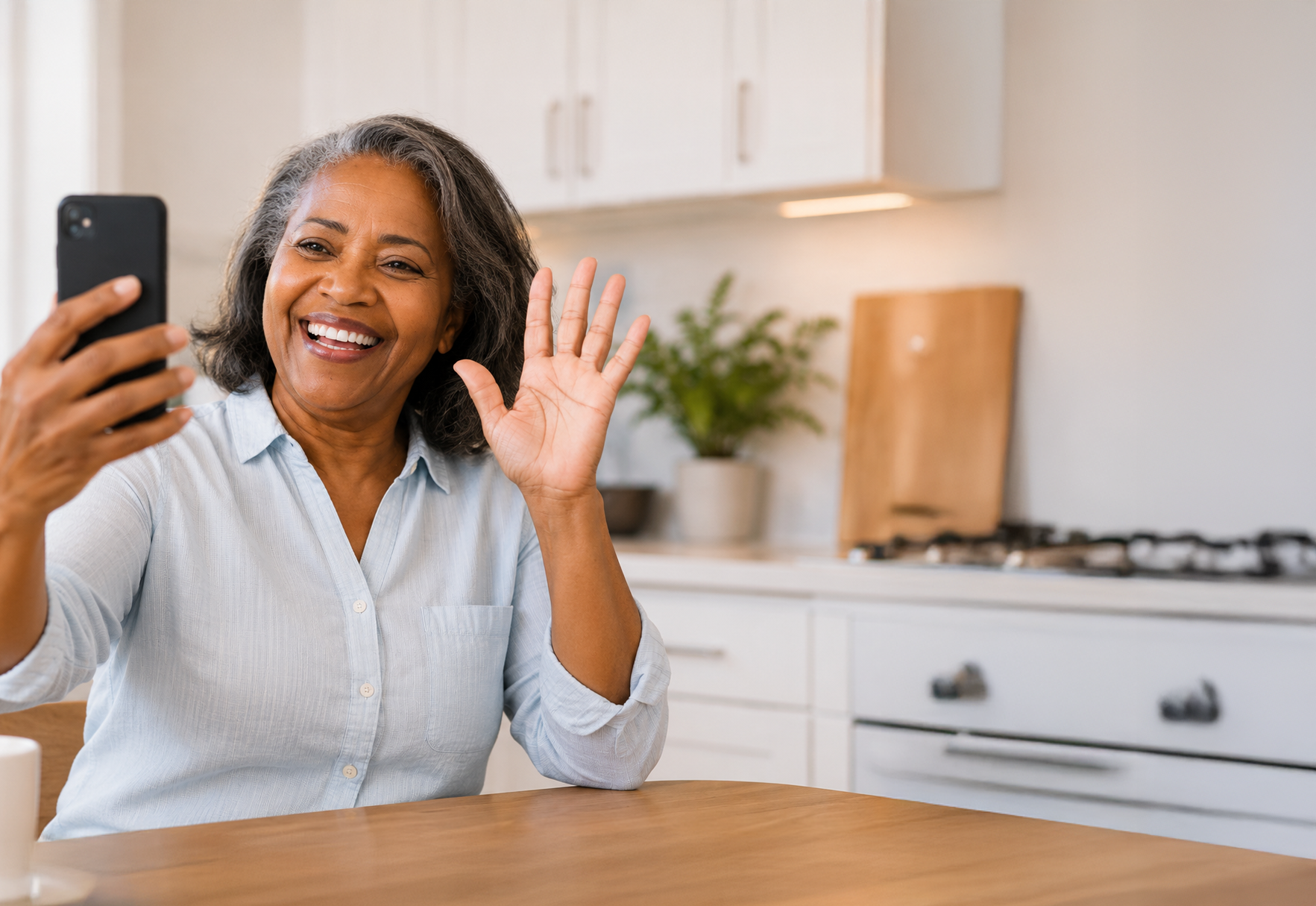 Woman waving at phone during video call