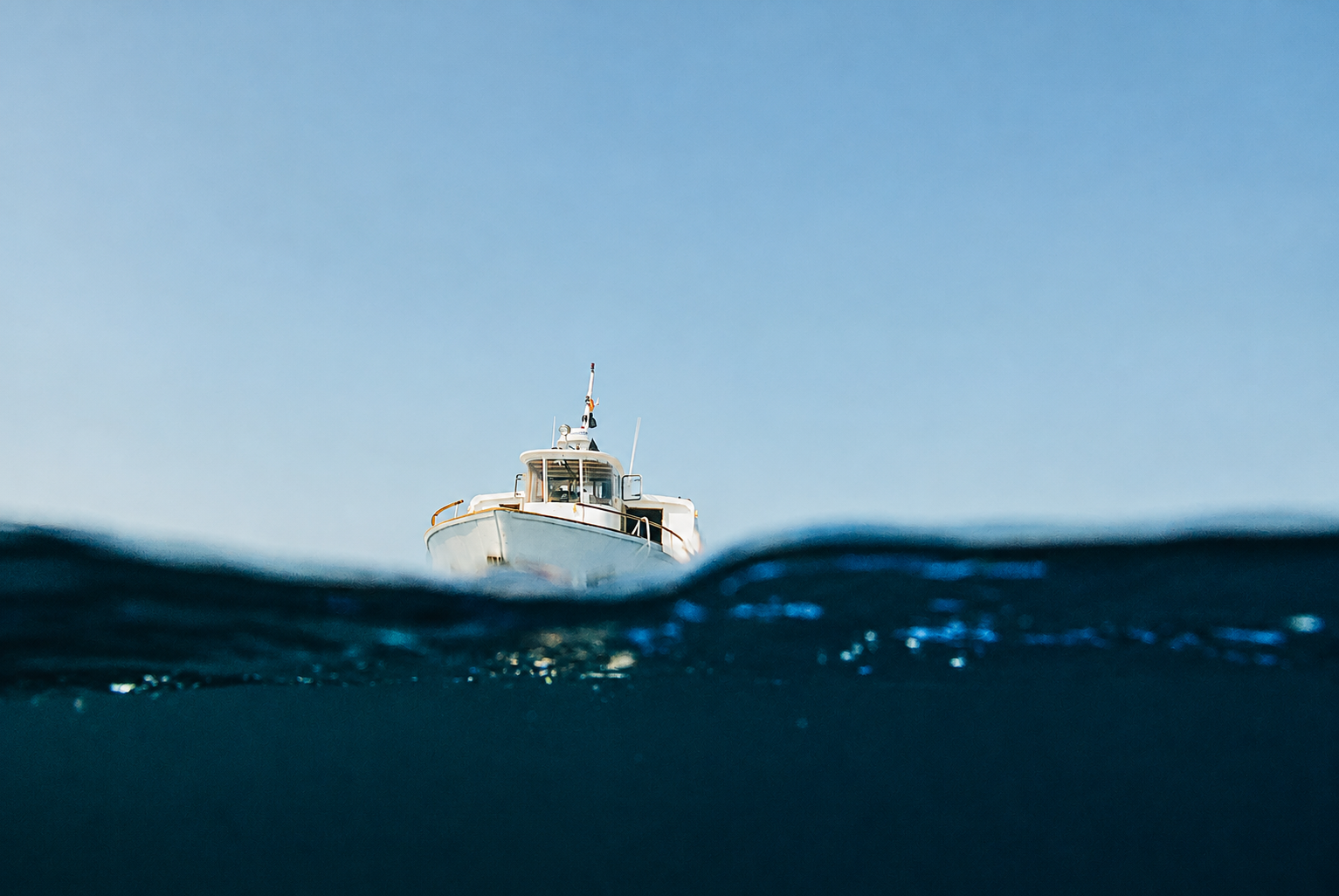 Fishing boat rising above deep ocean waves