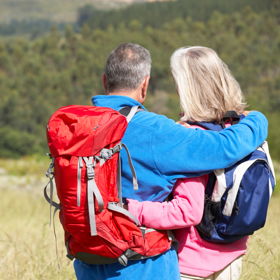 An active older couple with hiking backpacks enjoying the outdoors after bioidentical hormone therapy at Prime IV Flemington