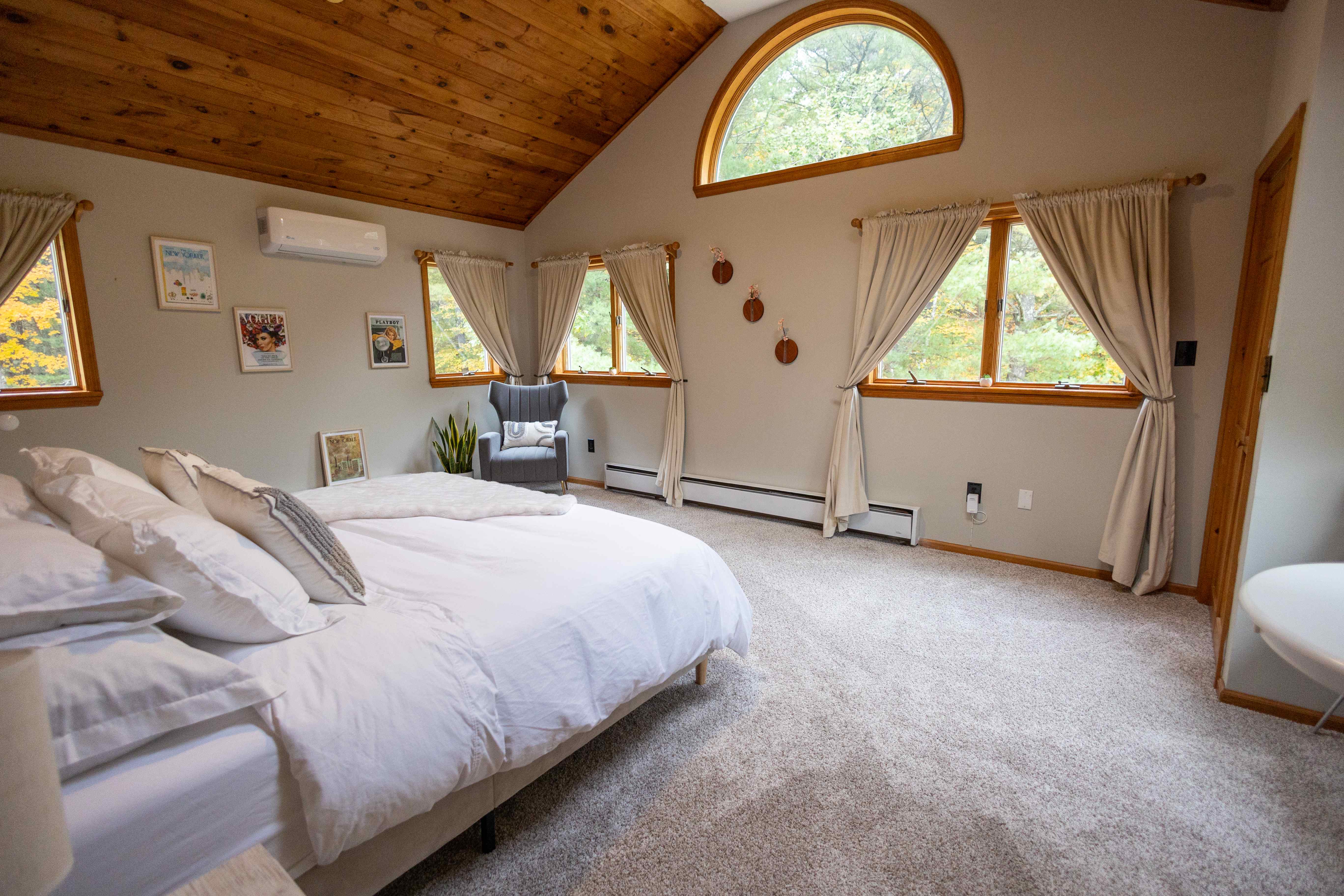 Master bedroom with vaulted ceiling and arched window