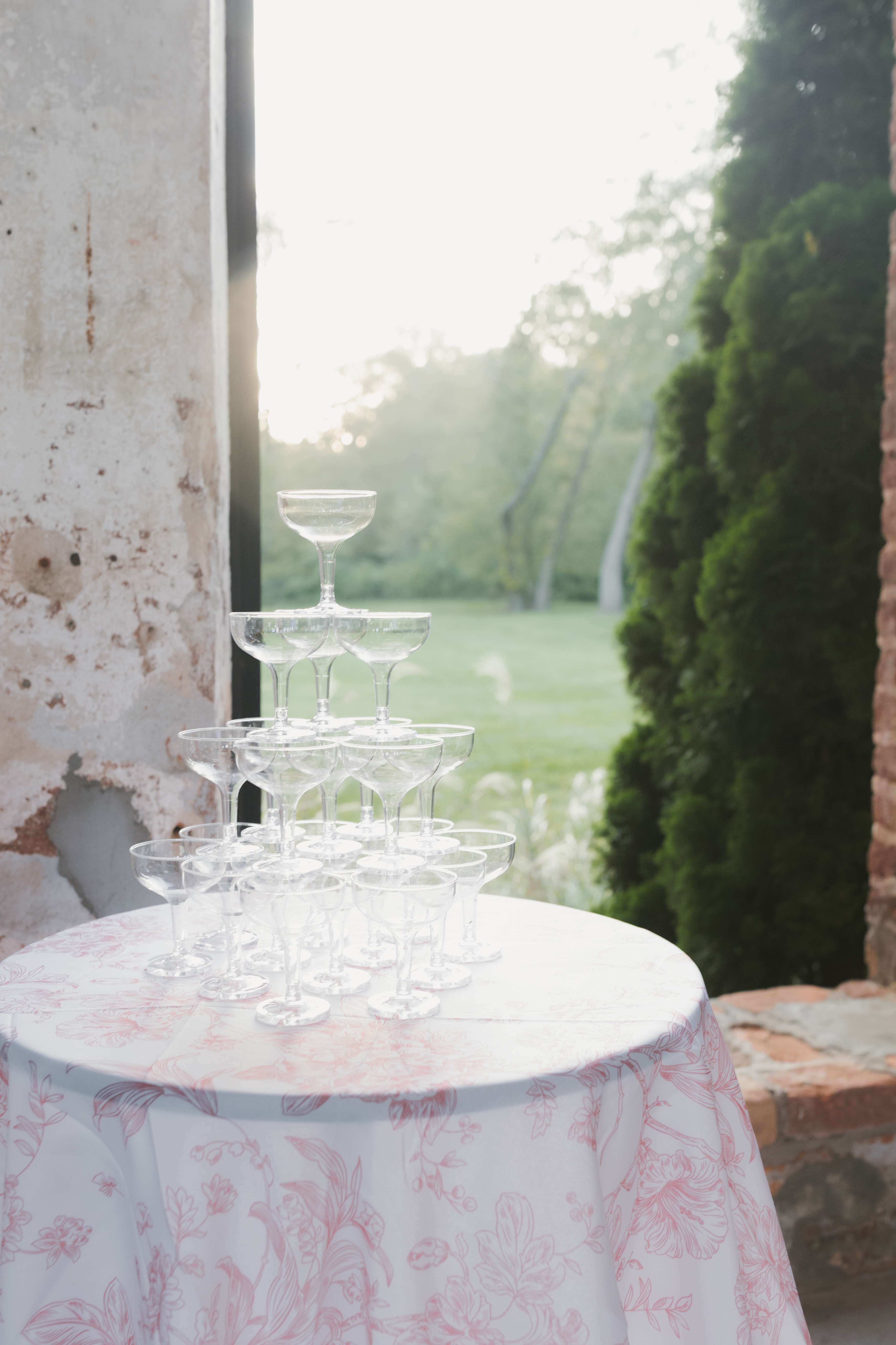 Champagne coupe tower on a floral linen at a garden reception
