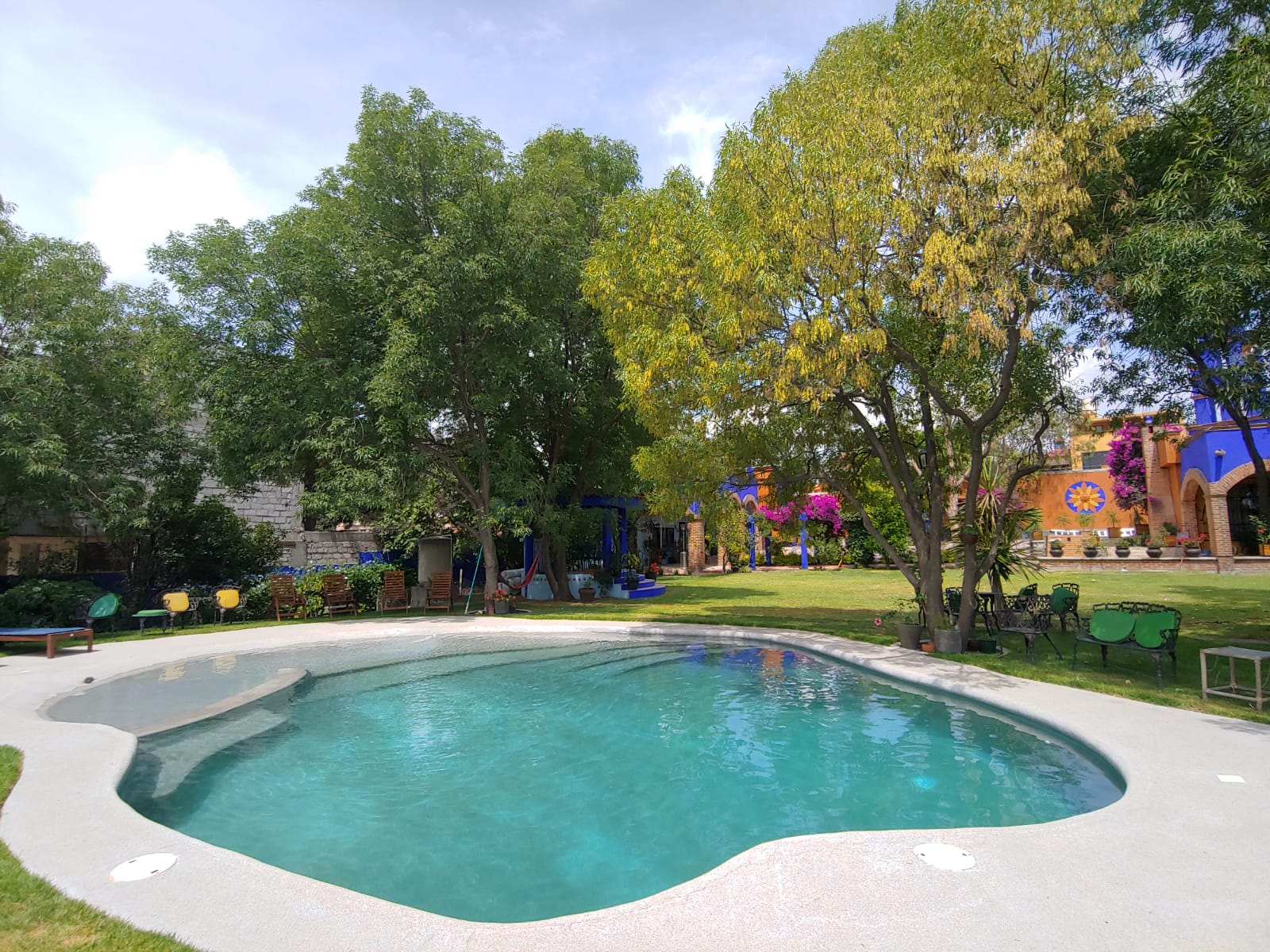 Alberca con arquitectura colonial y jardin