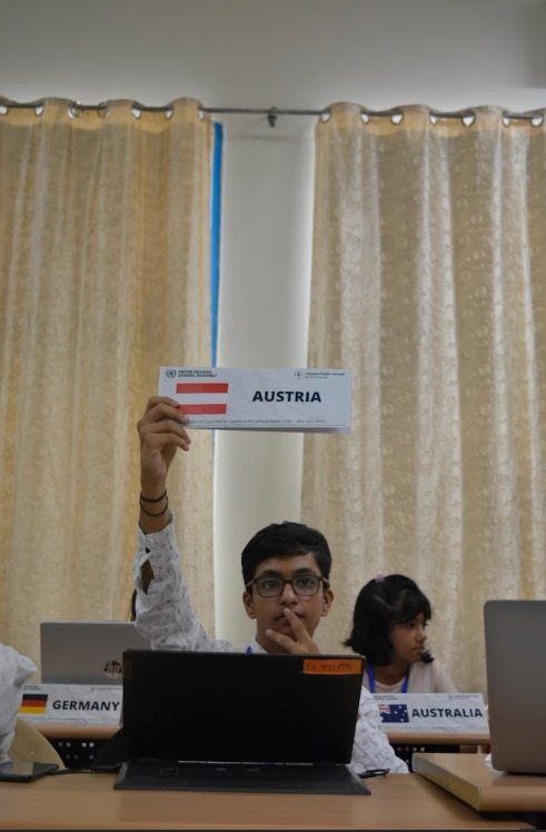 Akshat raising an Austria placard during a conference