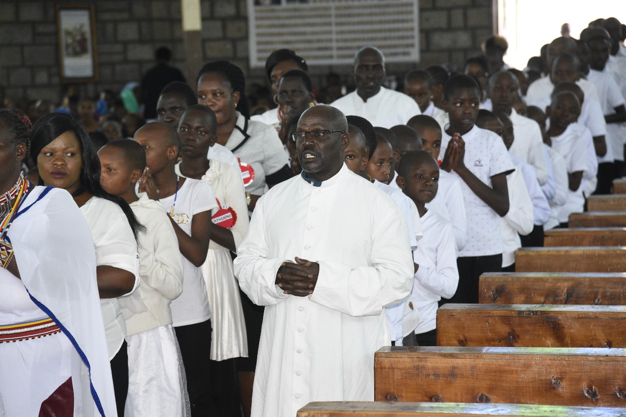 Congregation gathered in prayer with the priest during Mass