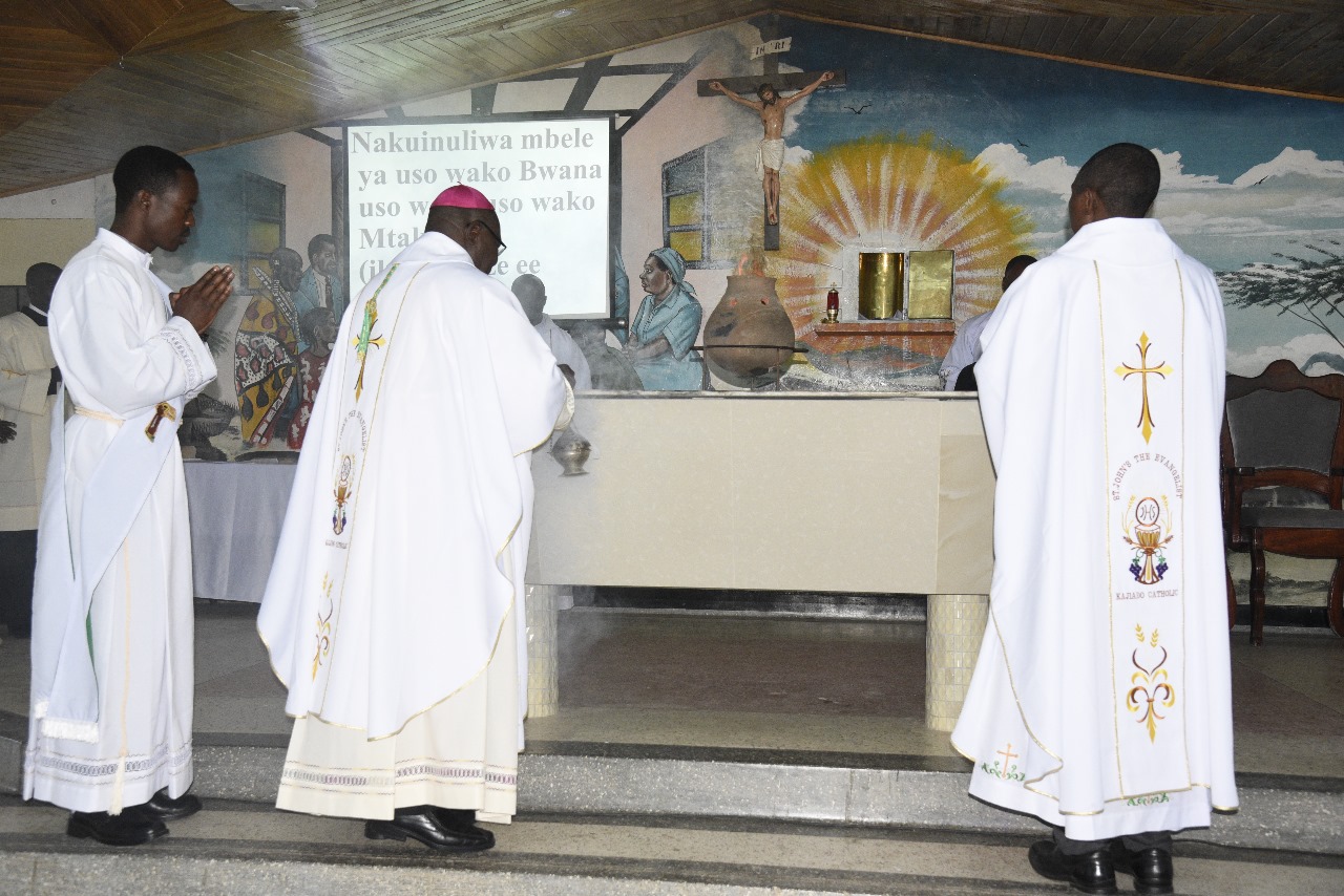 Bishop in white vestments celebrating Mass at the altar with other clergy members, representing the early missionary work