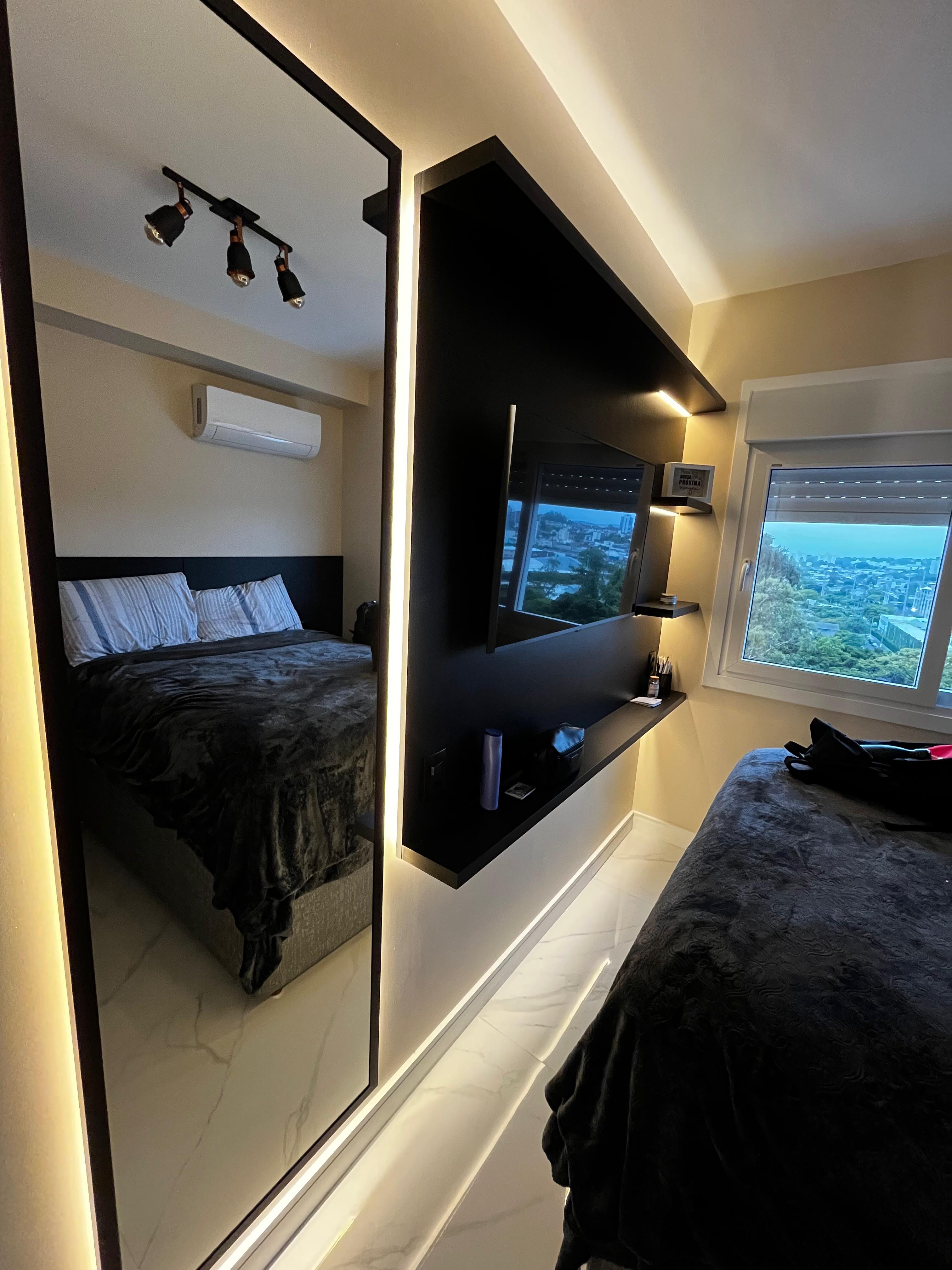 Quarto moderno com espelho iluminado e parede de destaque