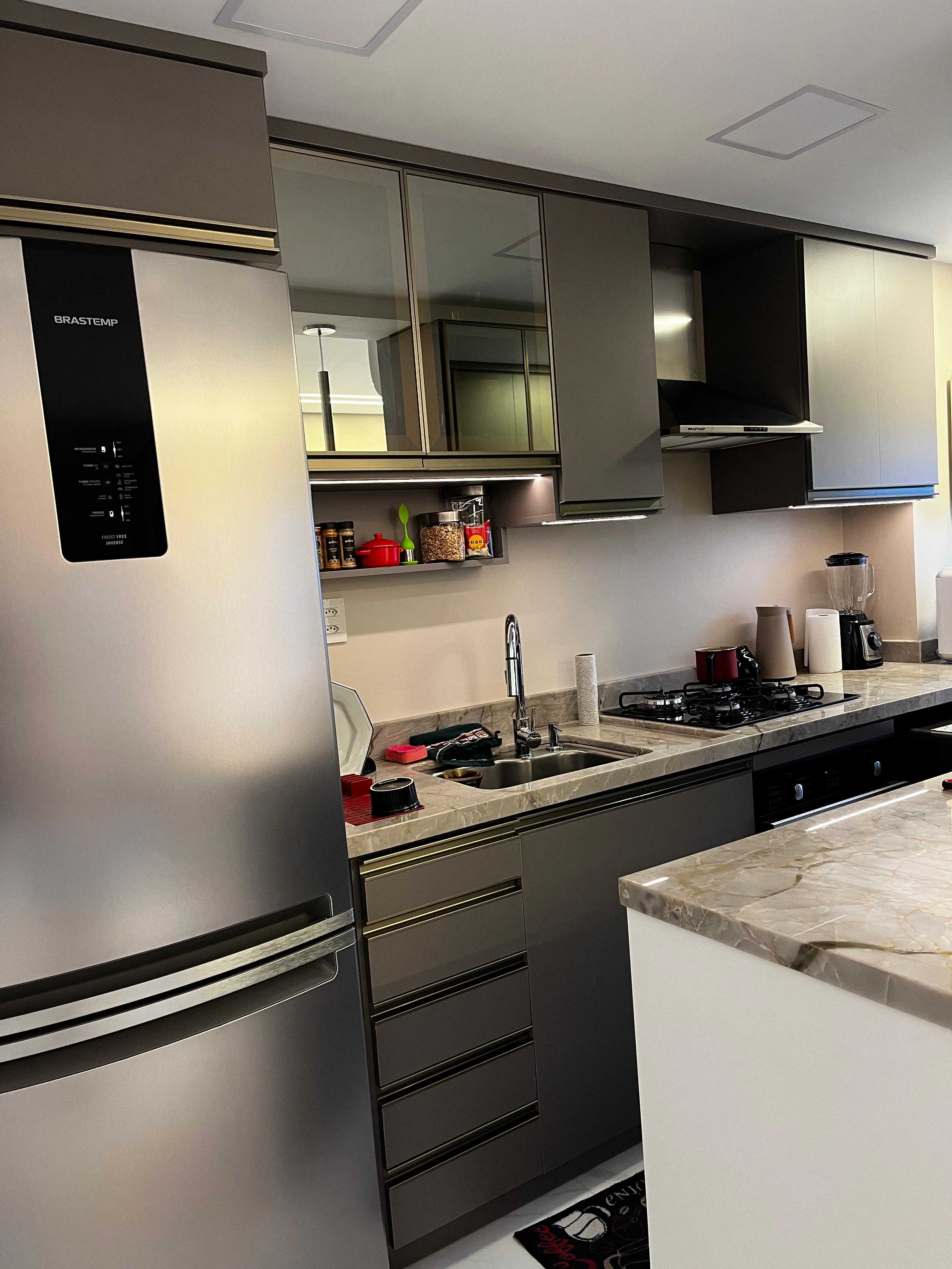 Cozinha moderna com armários cinza e bancada de mármore