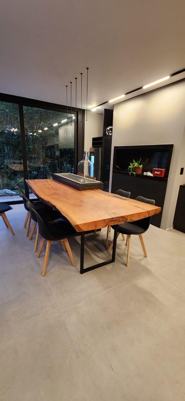 Sala de jantar moderna com mesa de madeira maciça e pendentes decorativos