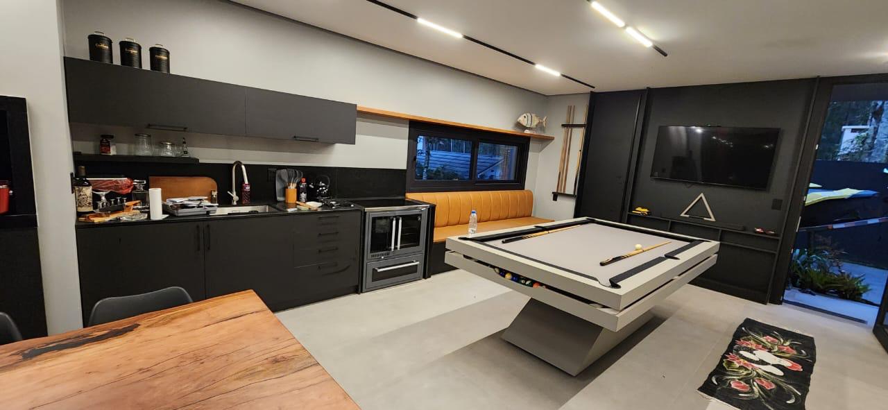 Área de entretenimento com mesa de sinuca e cozinha integrada