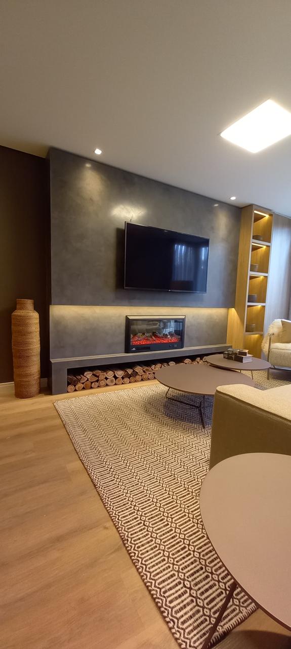 Living aconchegante com lareira elétrica, TV e nichos iluminados