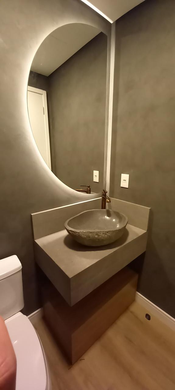 Lavabo moderno com espelho oval retroiluminado e bancada suspensa