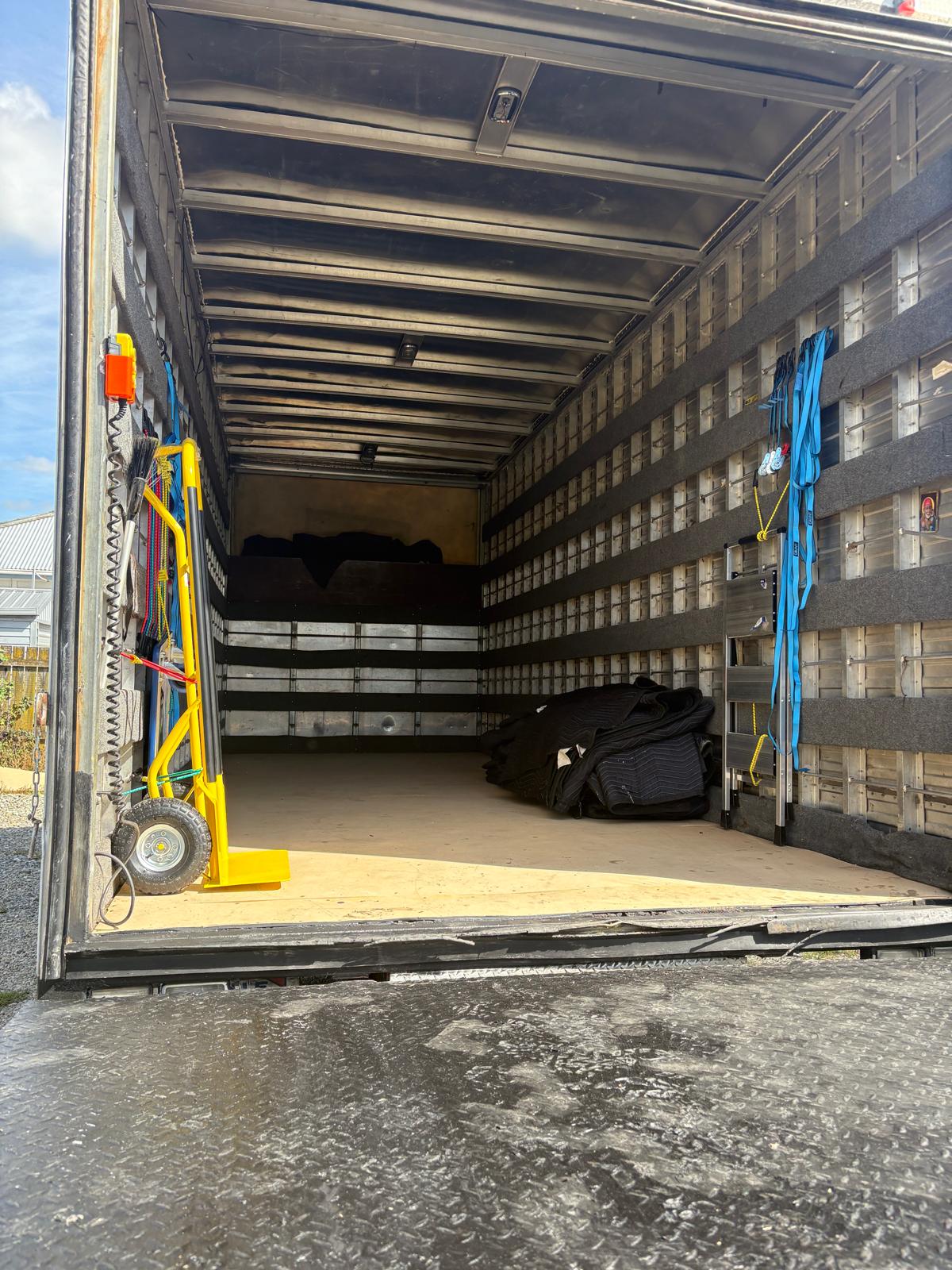 Truck interior showing straps and moving blankets