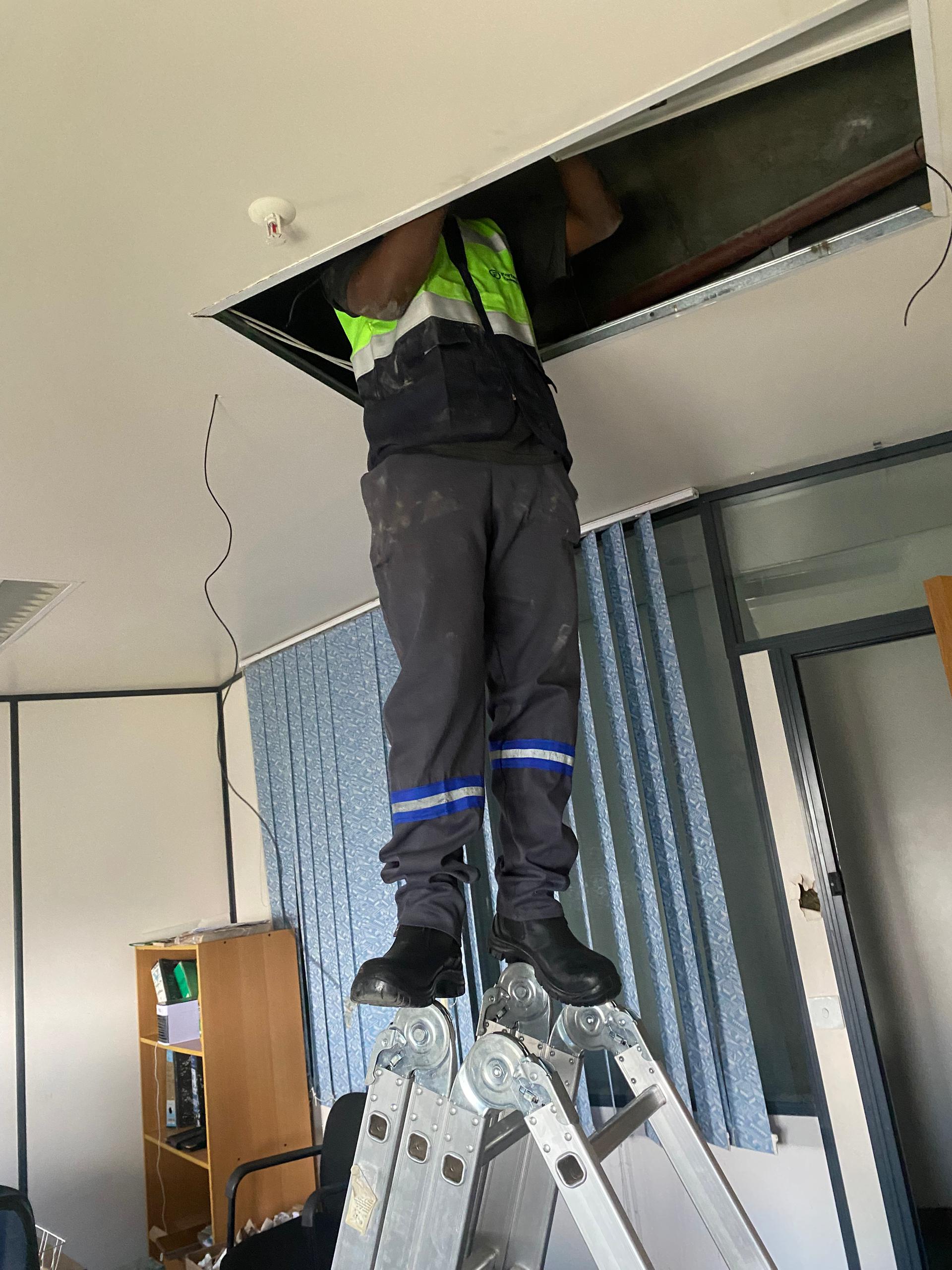 Engineer accessing ceiling infrastructure during an office installation