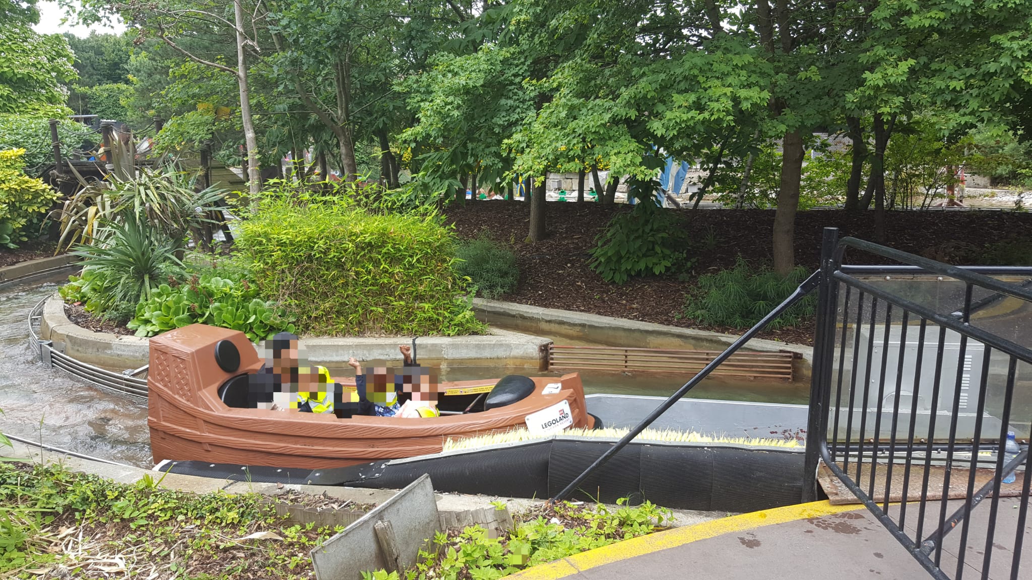 Children in boat-shaped attraction at water play area